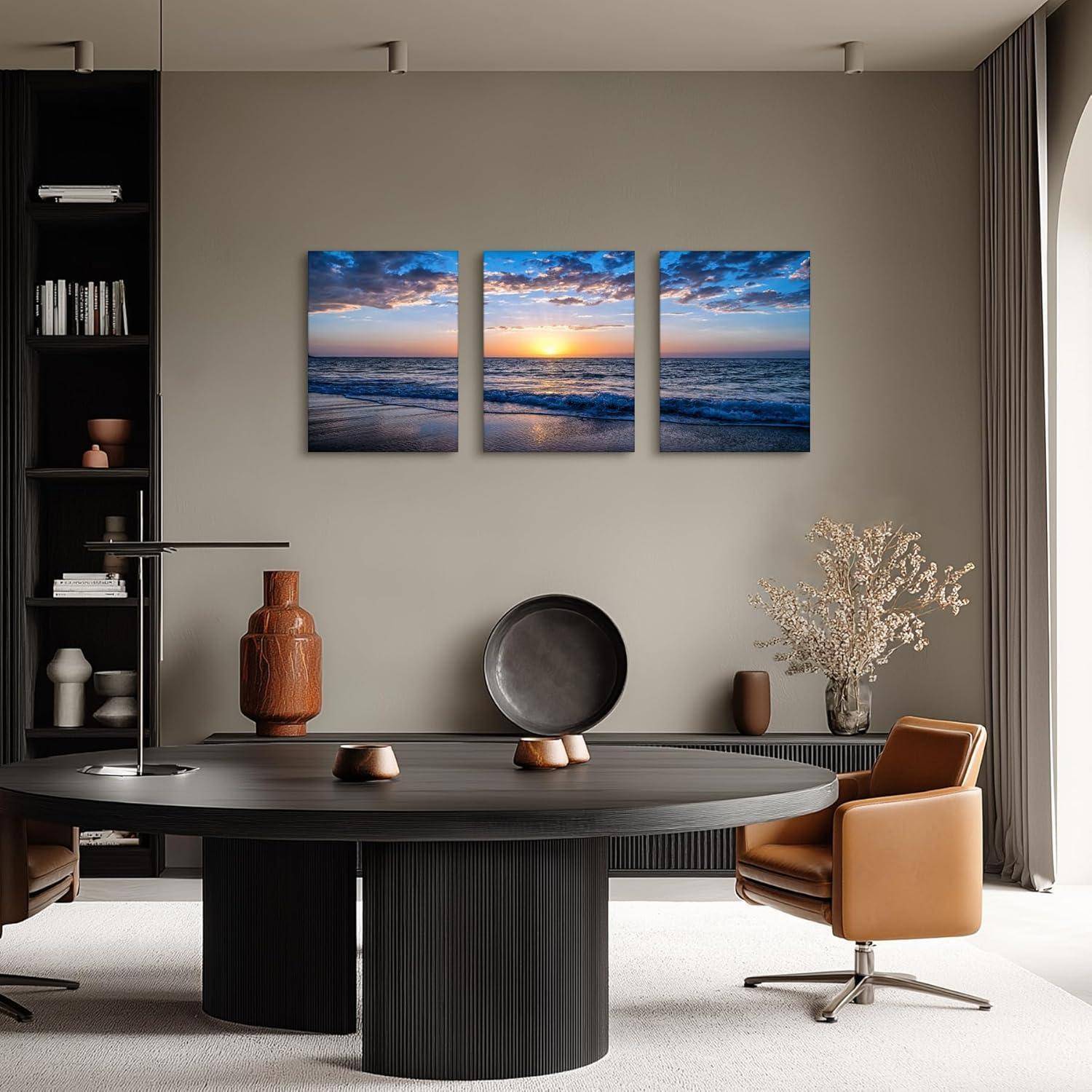 Ein modernes Wohnzimmer mit einem dunklen Holztisch, zwei braunen Stühlen, dekorativen Vasen und einem Triptychon eines Ozeansonnenenuntergangs an der Wand.