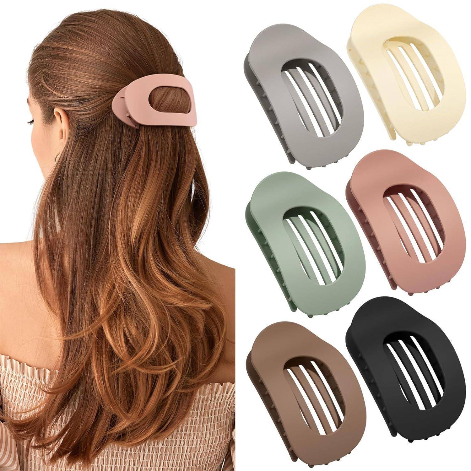 Eine Frau mit langen Haaren trägt eine große pinke Haarspange. In der Nähe sind fünf ähnliche Spangen in verschiedenen Farben (grau, beige, grün, rosa, schwarz) ausgelegt.