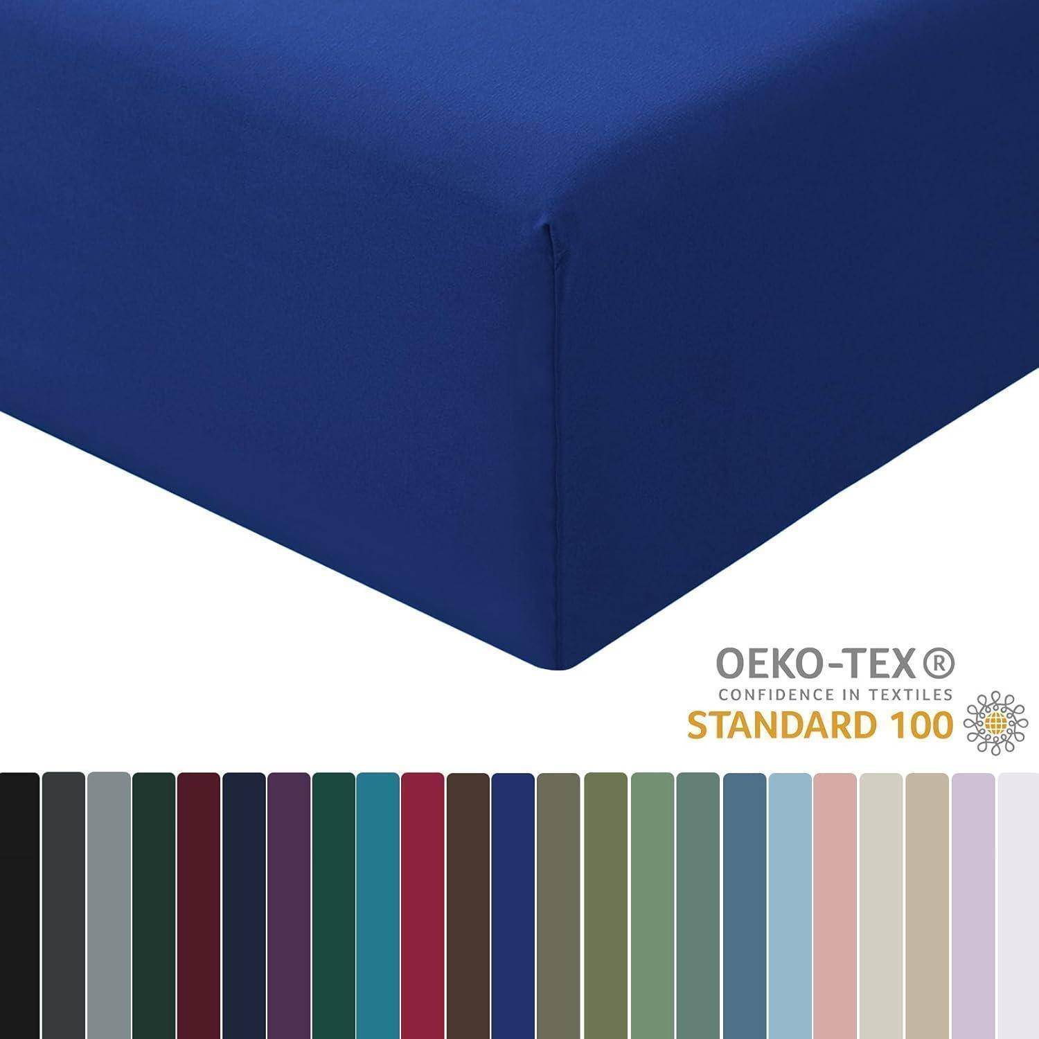 Tiefblaues Spannbettlaken mit OEKO-TEX Standard 100 Zertifizierung. Unten sind verschiedene Farbmuster in Grün, Rot, Marineblau und Beige zu sehen.