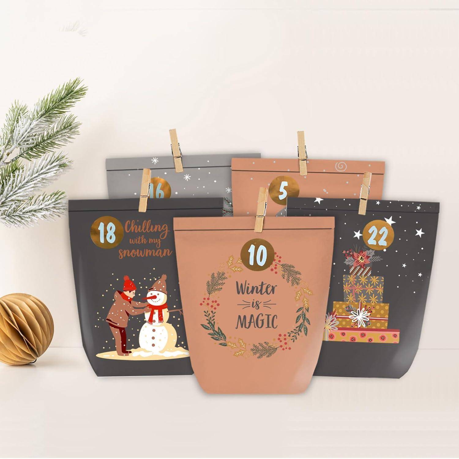 Vier dekorative Taschen mit den Nummern 5, 10, 18 und 22 in einem Winterthema, mit einem Schneemann, Geschenken und dem Schriftzug „Winter ist Magie