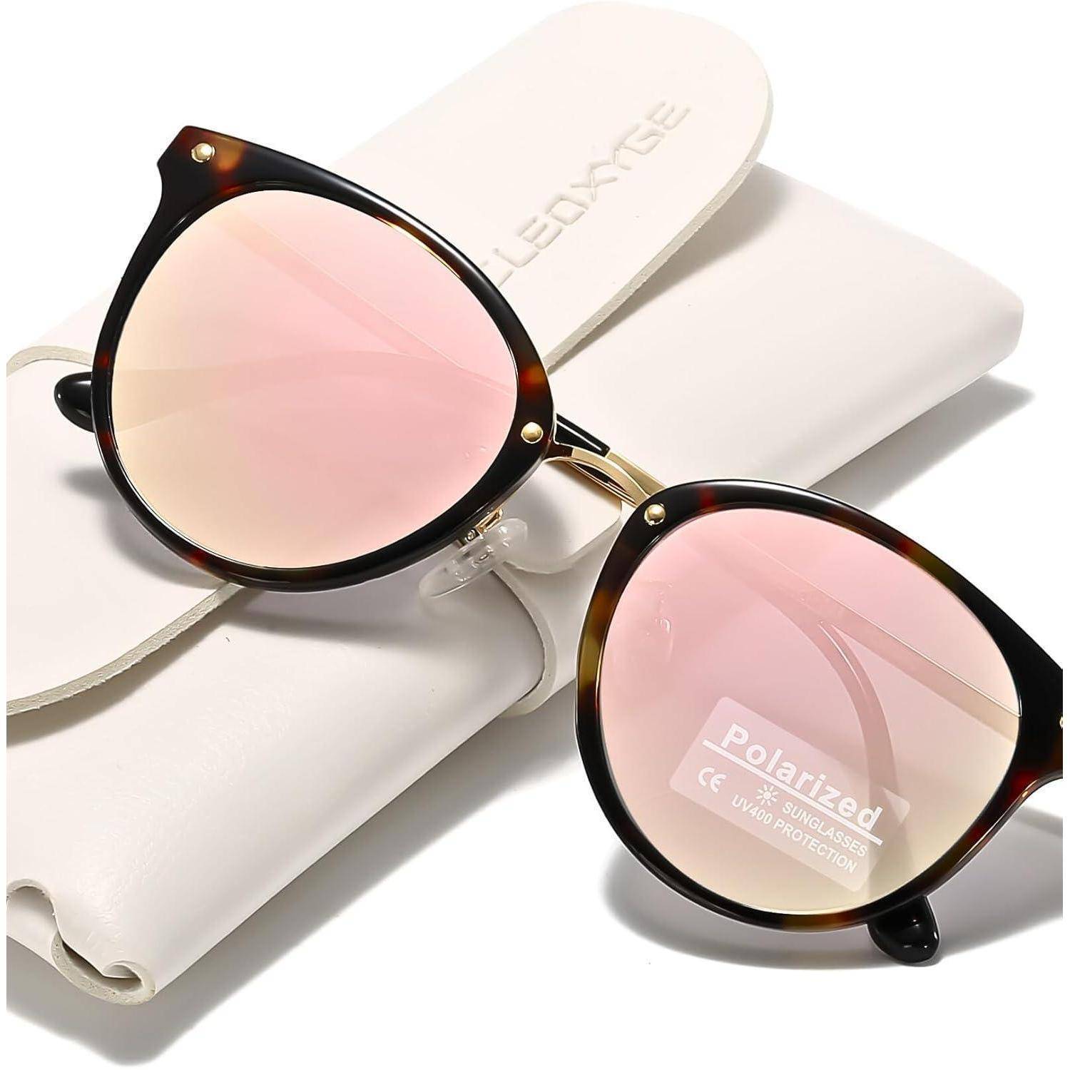 Runde Sonnenbrille mit rosa getönten polarisierten Gläsern ruht auf einem weißen Etui mit der Aufschrift 