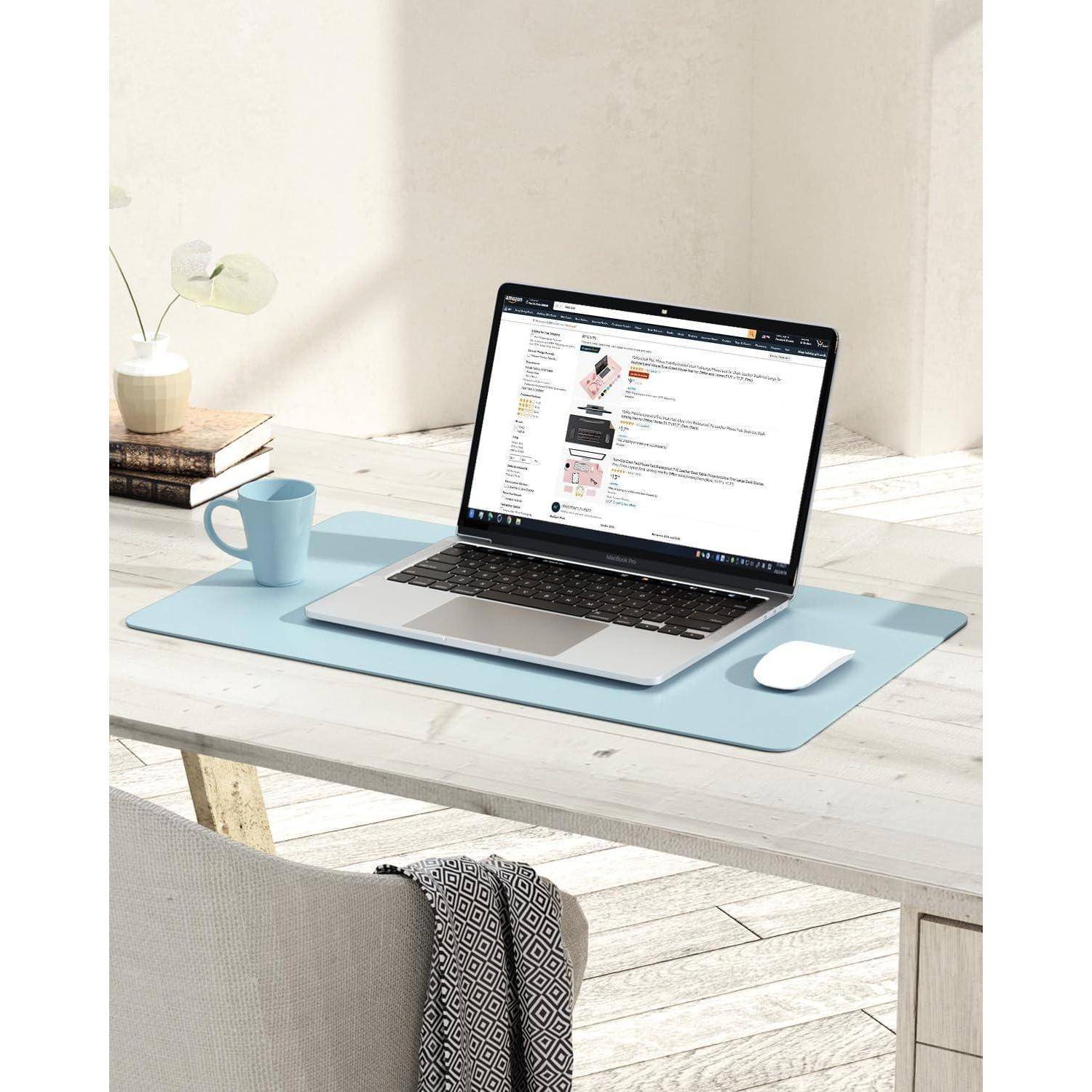 Ein Laptop auf einem Schreibtisch, der eine Online-Shopping-Website anzeigt, mit einer Tasse, einer Maus, einer Pflanze und einem Notizblock in der Nähe, in einem hellen, minimalistischen Raum.