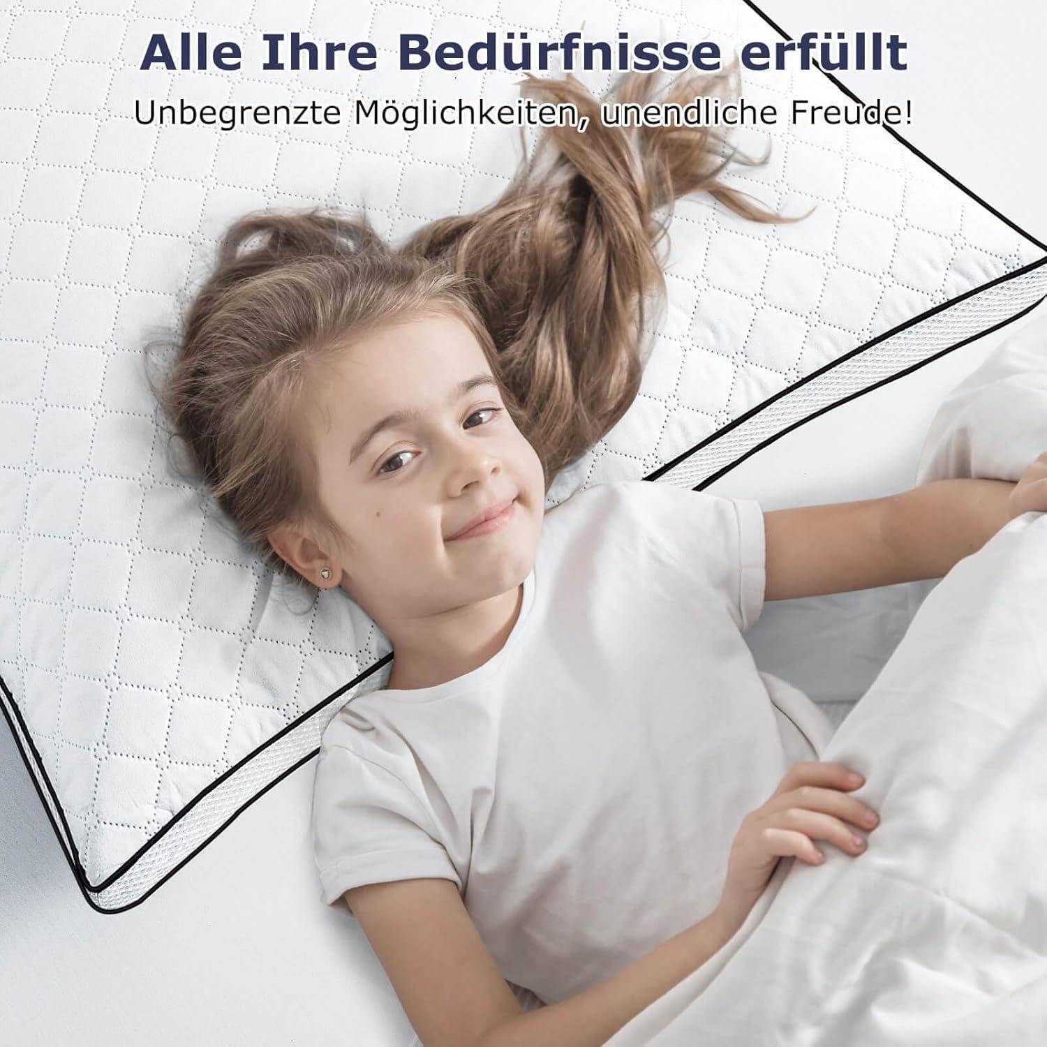 Ein lächelndes Kind liegt auf einem weißen Kissen und wirkt zufrieden. Der Text darüber lautet „Alle Ihre Bedürfnisse erfüllt