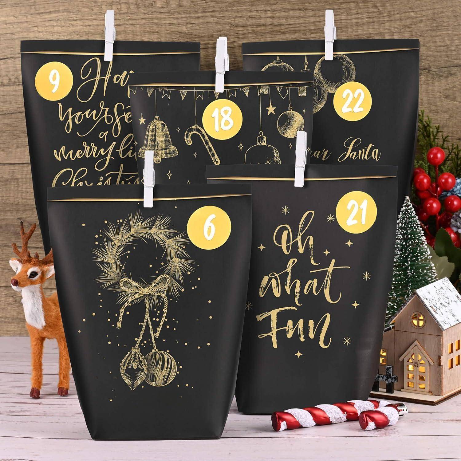 Weihnachtlicher Adventskalender mit schwarzen Tüten, die goldene Designs und die Nummern 6, 9, 18, 21 tragen. Hintergrund: festliche Dekoration mit Lichtern, Rentieren und einem kleinen Hausmodell.