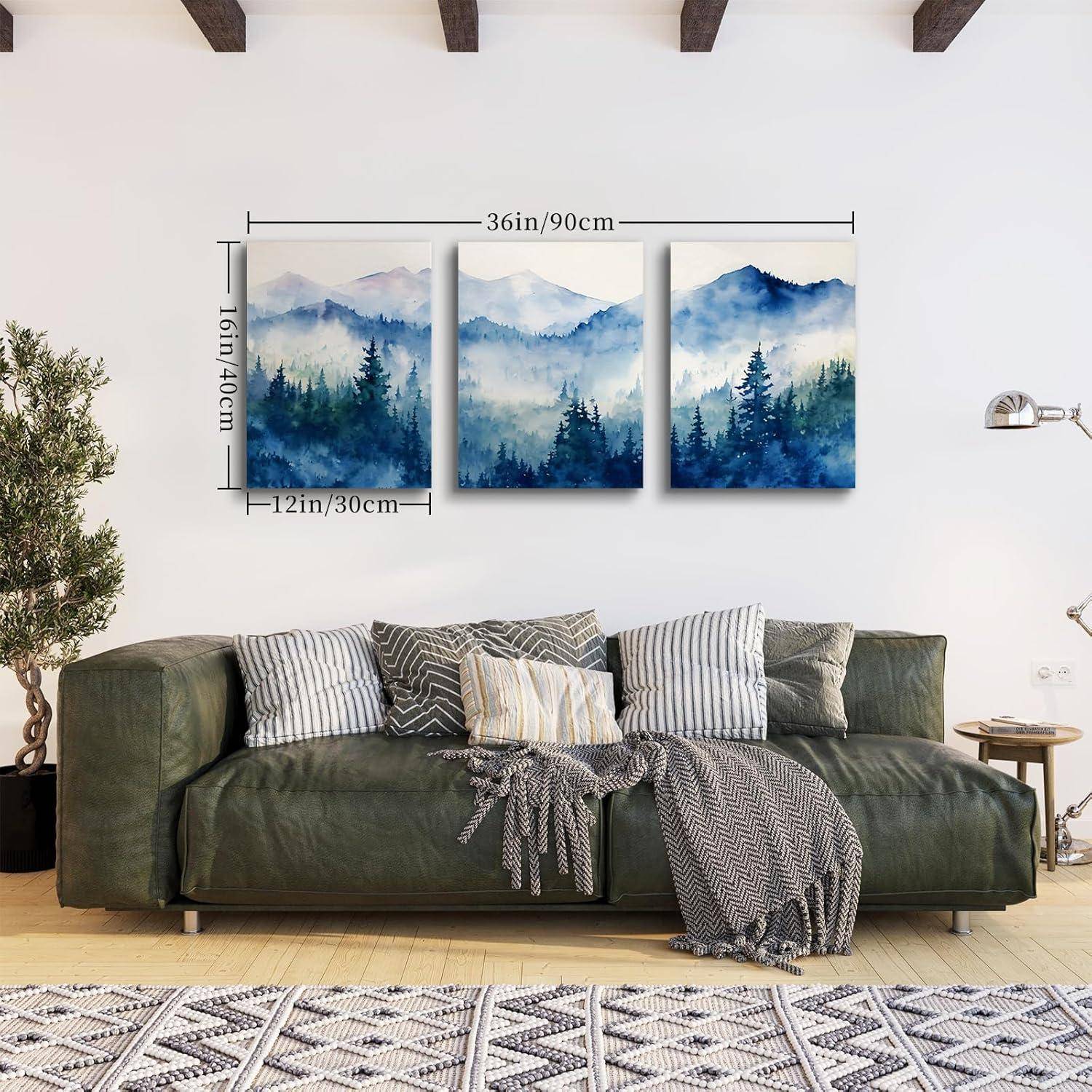 Ein Wohnzimmer mit einem grünen Sofa, geschmückt mit Kissen und einer Decke. Darüber sind drei Gemälde mit Berglandschaften aufgehängt, die jeweils 12x16 Zoll messen.