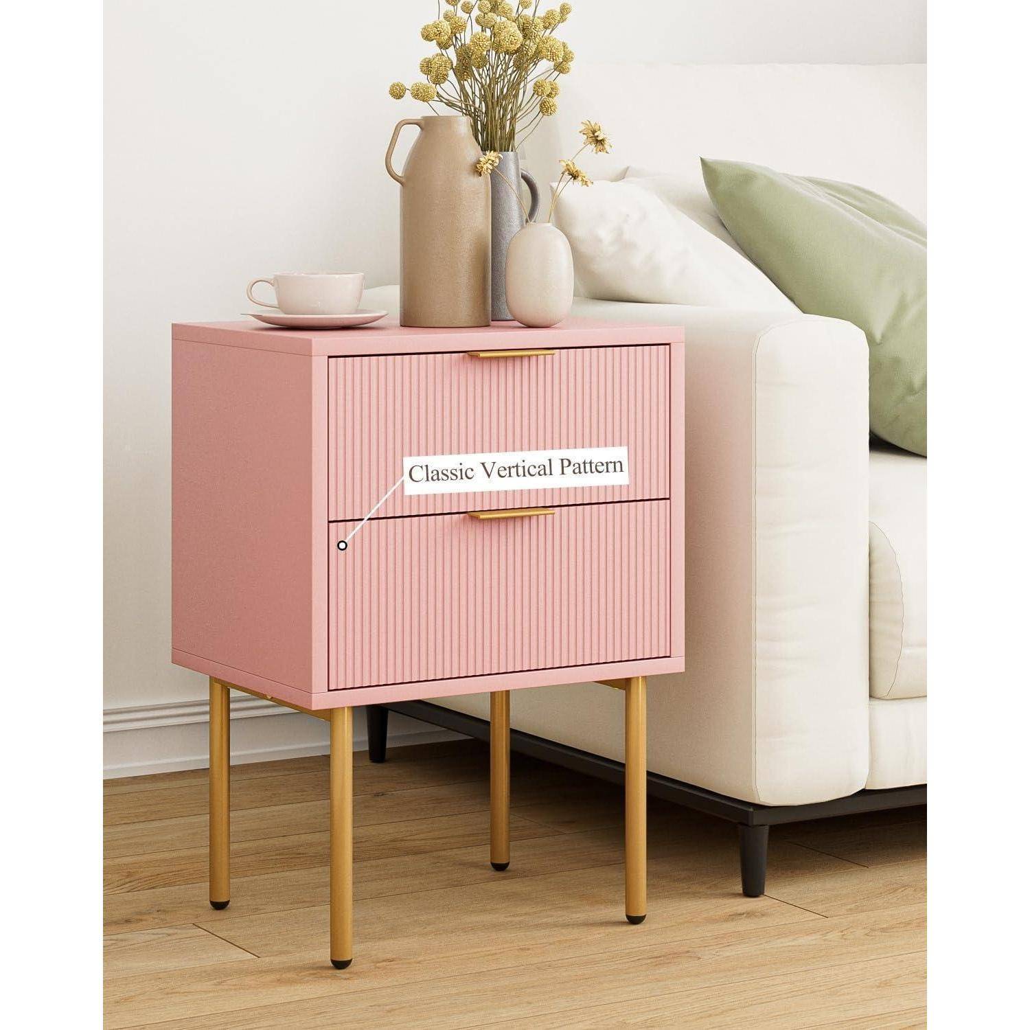 Ein rosa Nachttisch mit goldenen Beinen und Griffen, mit der Aufschrift 