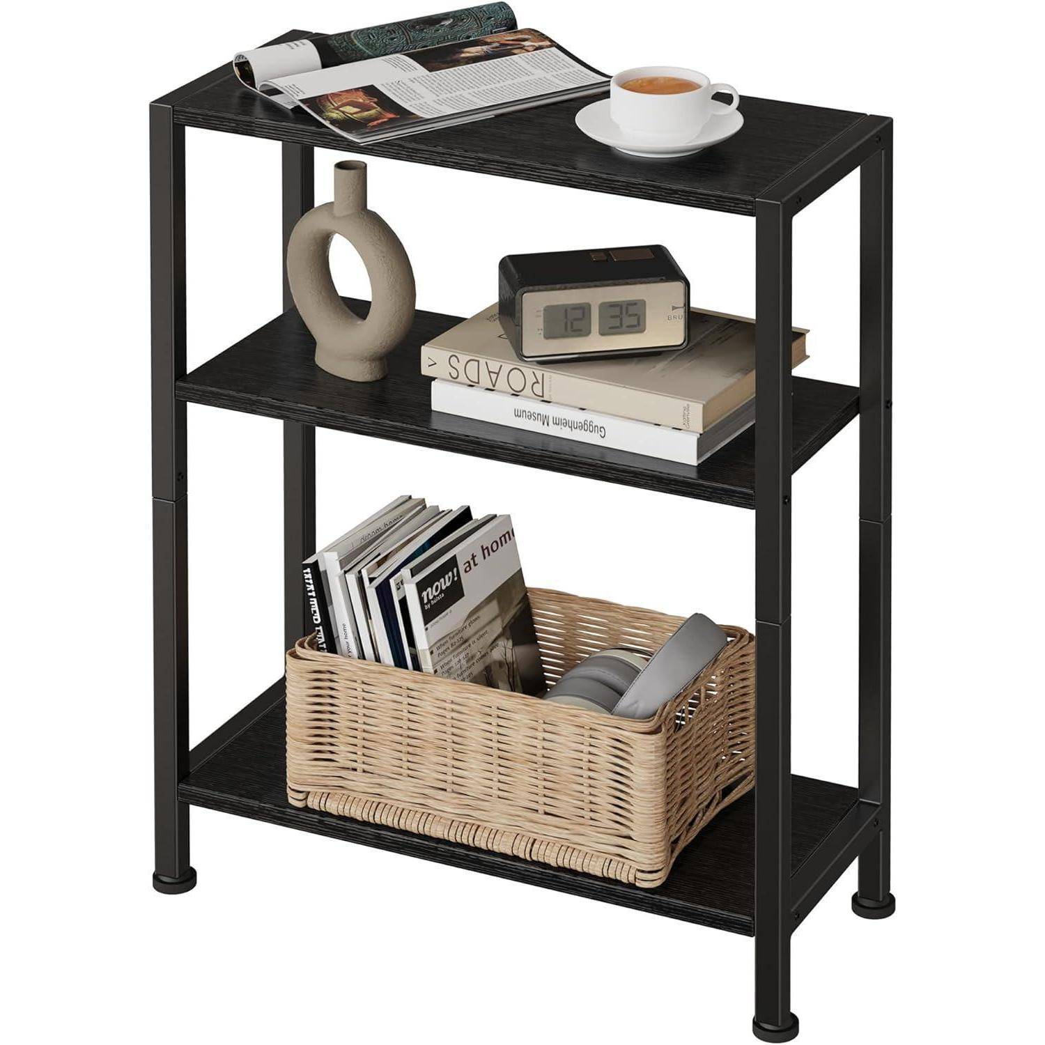 Ein schwarzes, dreistufiges Regal mit einer Kaffeetasse, einer Ziervase, einer Uhr und Zeitschriften auf dem obersten Regal; Bücher und ein geflochtener Korb darunter.
