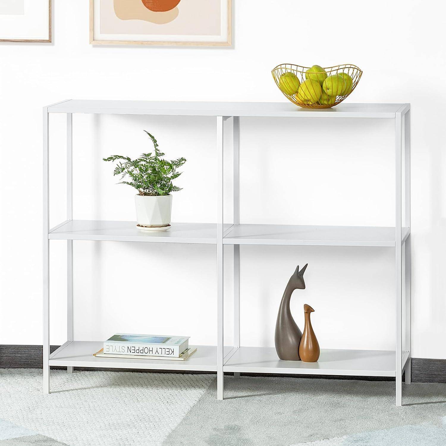 Ein minimalistisches weißes Metallregal mit einer Pflanze, einer Obstschale und dekorativen Figuren. Zwei abstrakte Gemälde hängen über dem Regal.