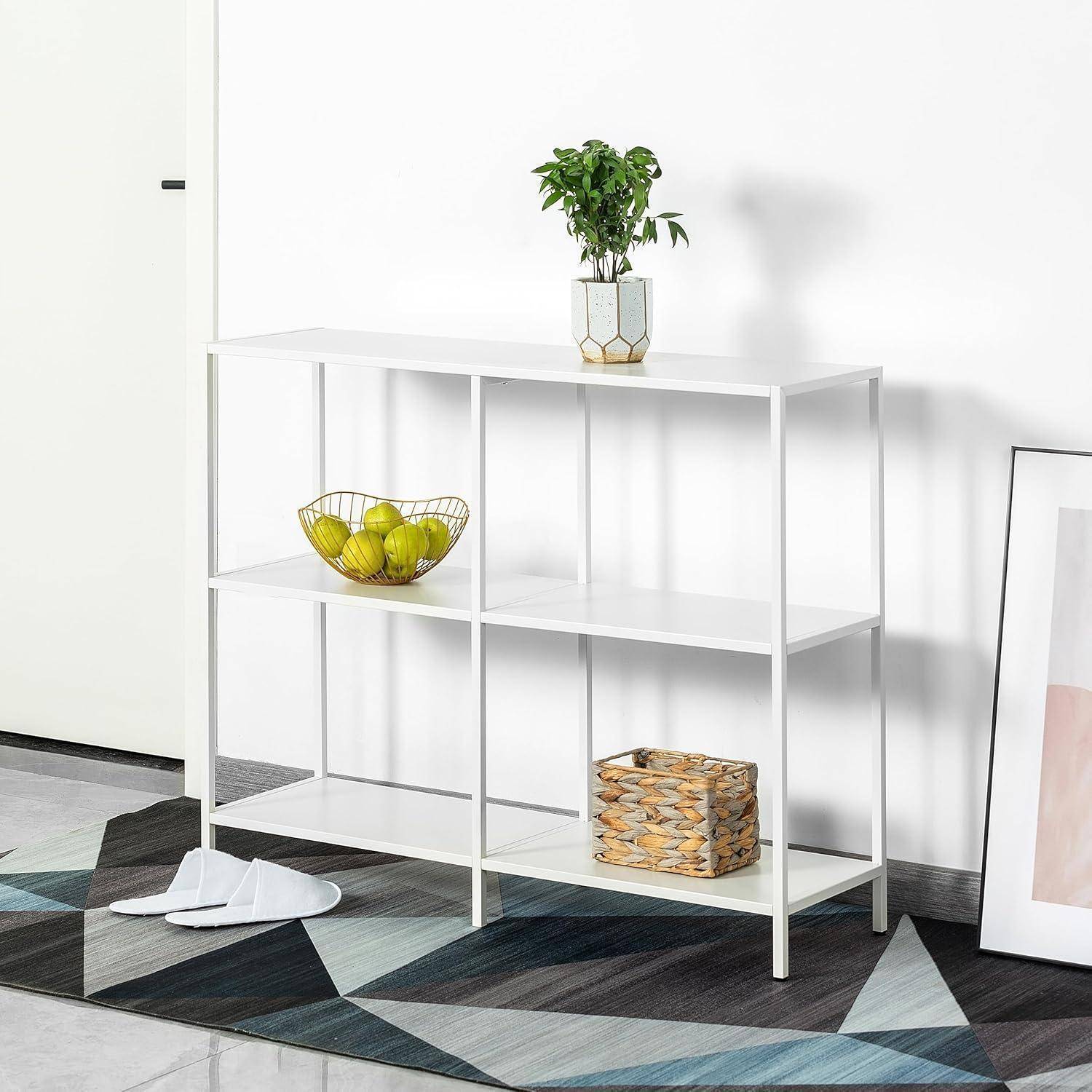Ein minimalistisches weißes Regalsystem mit Pflanzen und Dekoartikeln steht auf einem geometrisch gemusterten Teppich. Eine Schale mit grünen Äpfeln befindet sich auf einem der Regale.