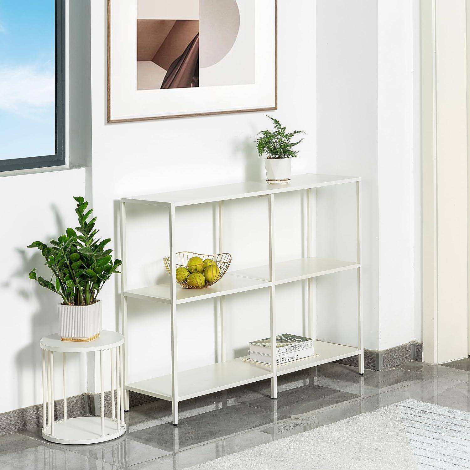 Ein minimalistisches Zimmer mit einem weißen Regal, das Zitronen und eine kleine Pflanze trägt, neben einem Fenster. Ein runder Tisch mit einer Topfpflanze steht in der Nähe.