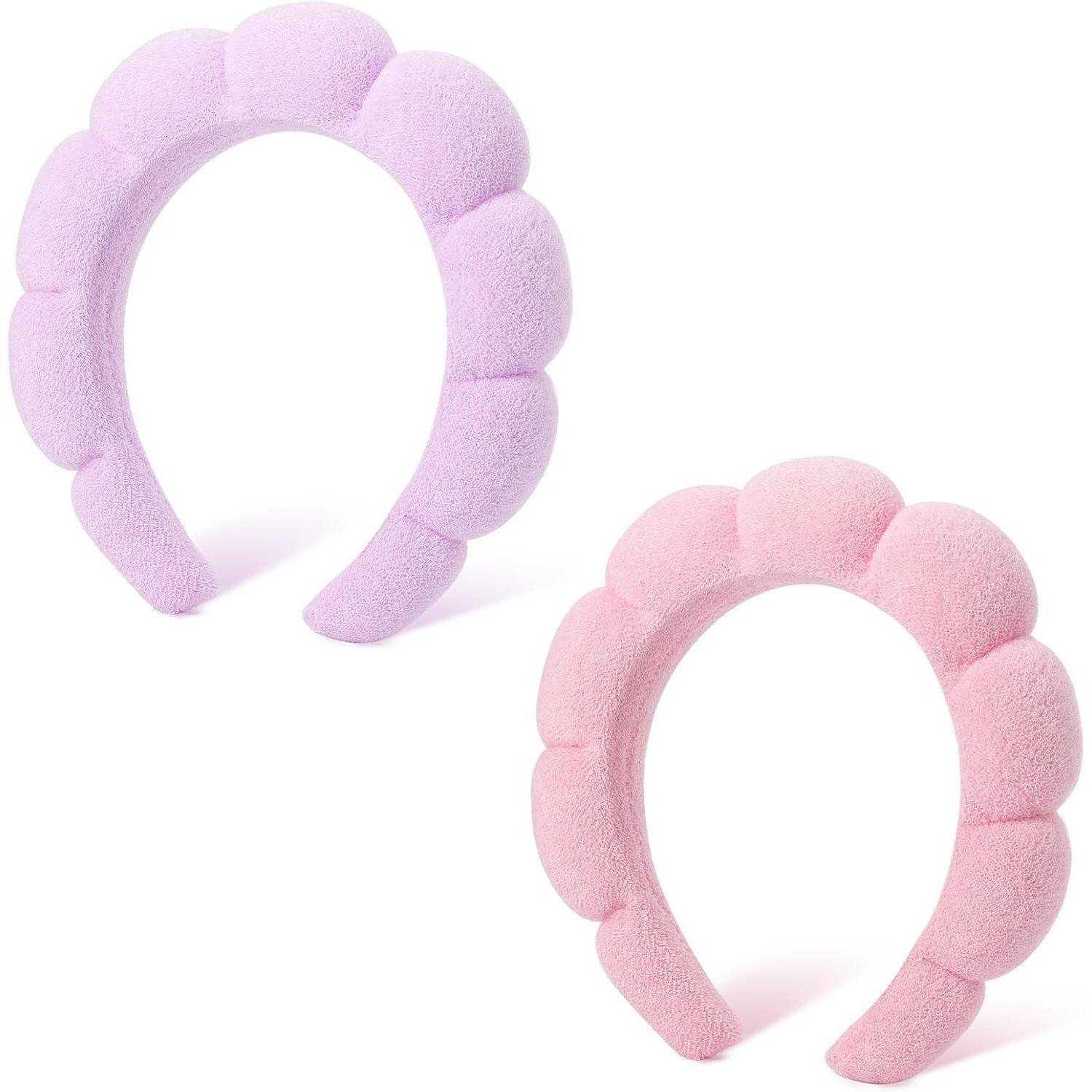 Zwei plüschige, wellenförmige Haarreife in hellem Lila und Rosa werden nebeneinander positioniert präsentiert.