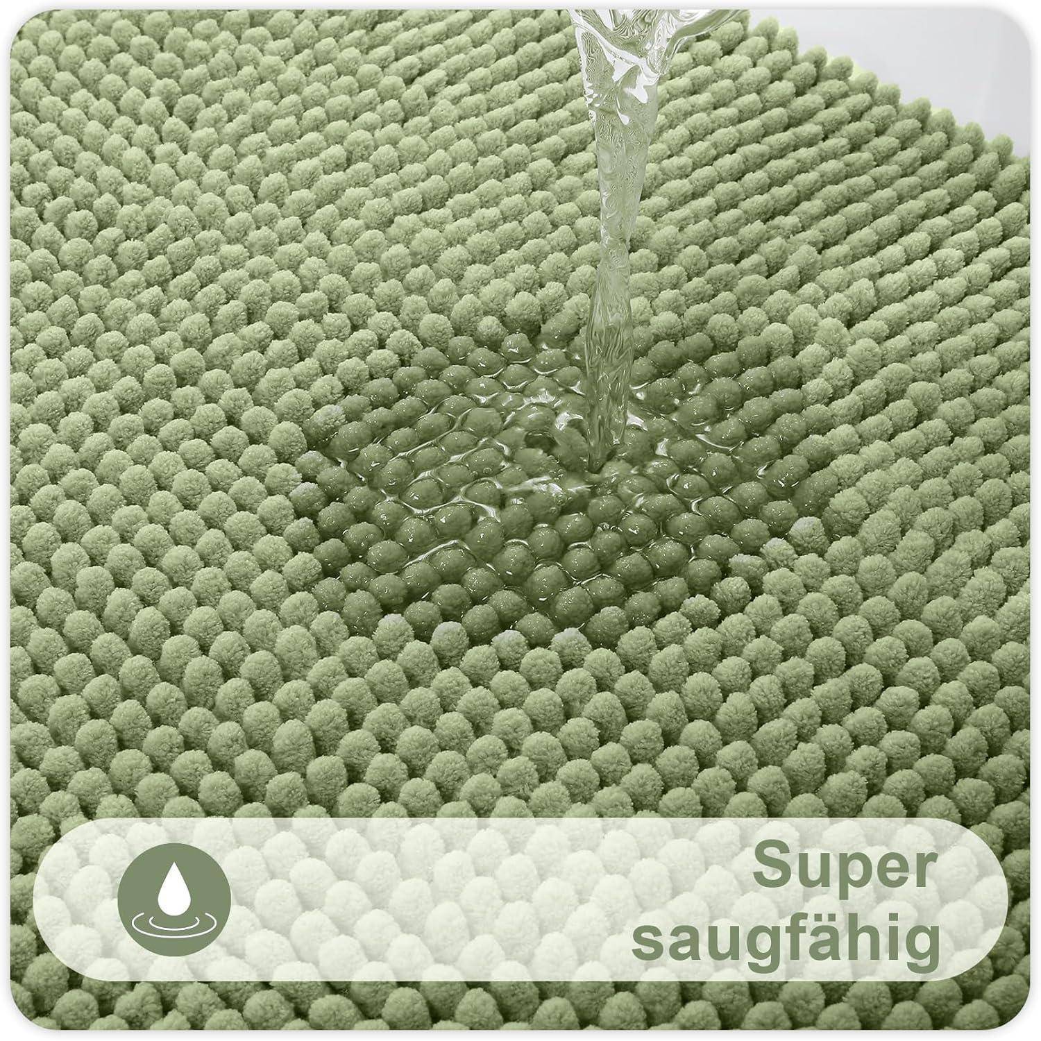 Ein grüner, strukturierter Badematte absorbiert Wasser, das auf sie gegossen wird, und zeigt dabei eine hohe Saugfähigkeit. Der Text darunter liest: 'Super saugfähig' mit einem Wassertropfen-Symbol.