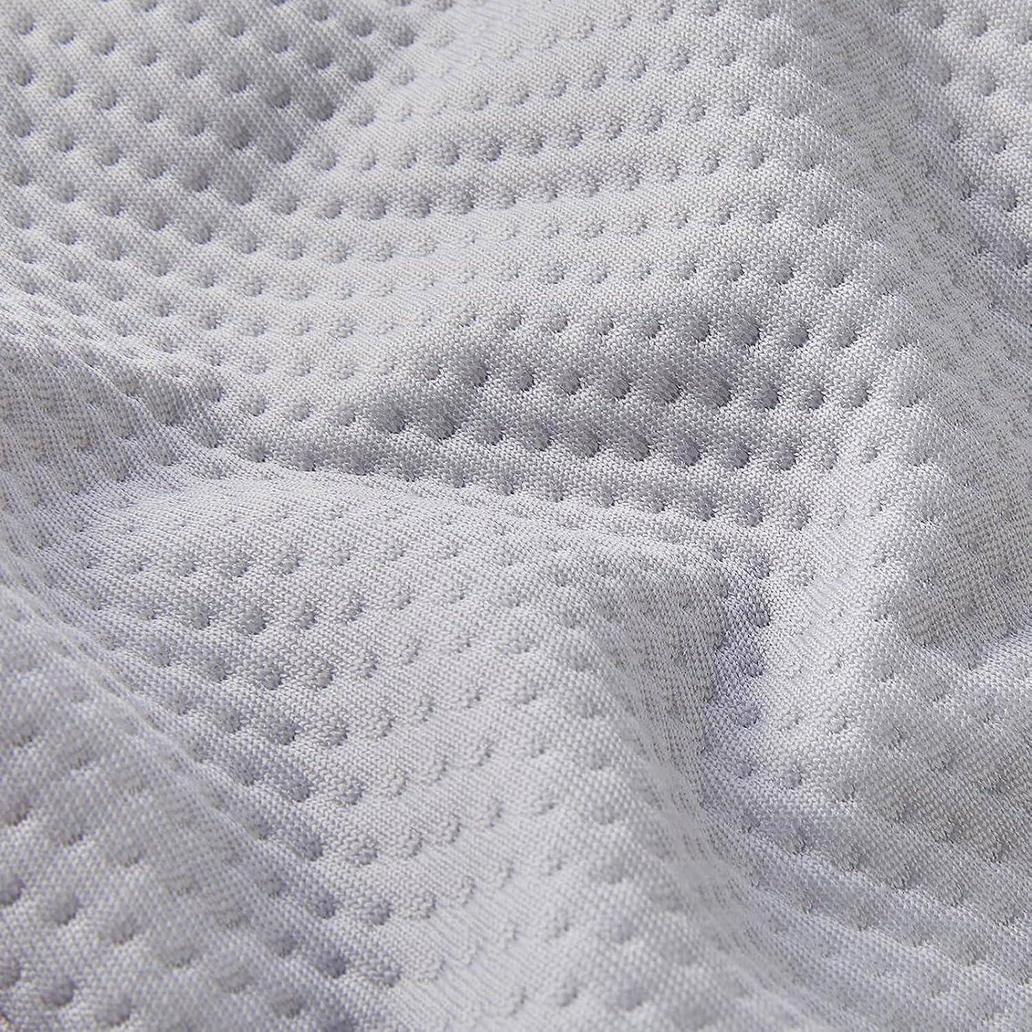 Detailaufnahme eines strukturierten weißen Stoffs mit einem Wabenmuster und dezenten Falten, die die Weichheit und Details des Materials betonen.