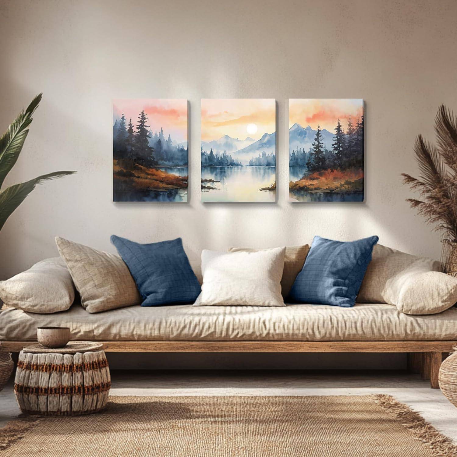 Ein gemütliches Wohnzimmer mit einem beigen Sofa, blauen und weißen Kissen und einer Reihe von drei Landschaftsgemälden, die Berge und einen See zeigen.