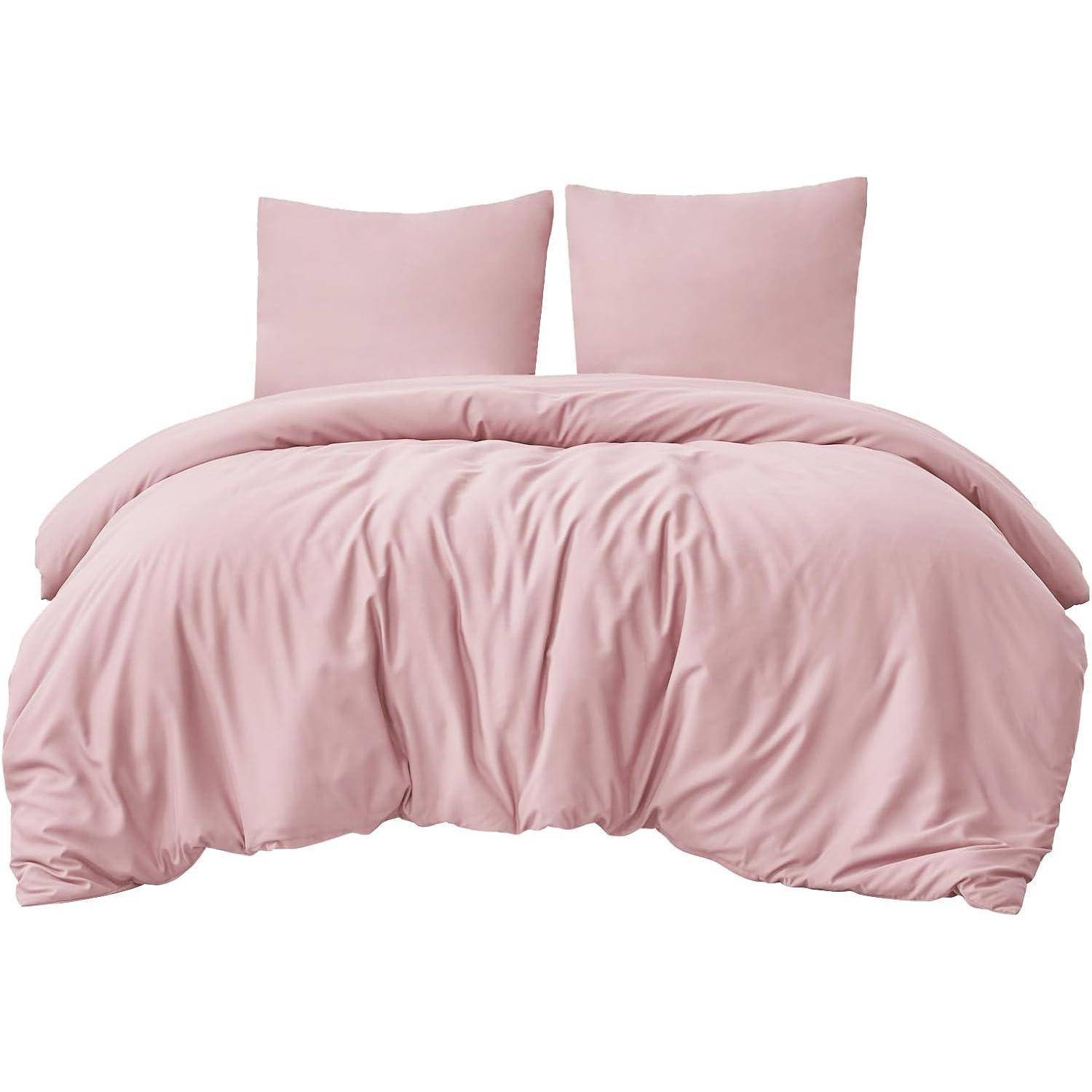 Ein weiches, rosa Bettwäsche-Set mit zwei Kissen und einer Bettdecke, das eine gemütliche und einladende Atmosphäre für ein Schlafzimmer schafft.