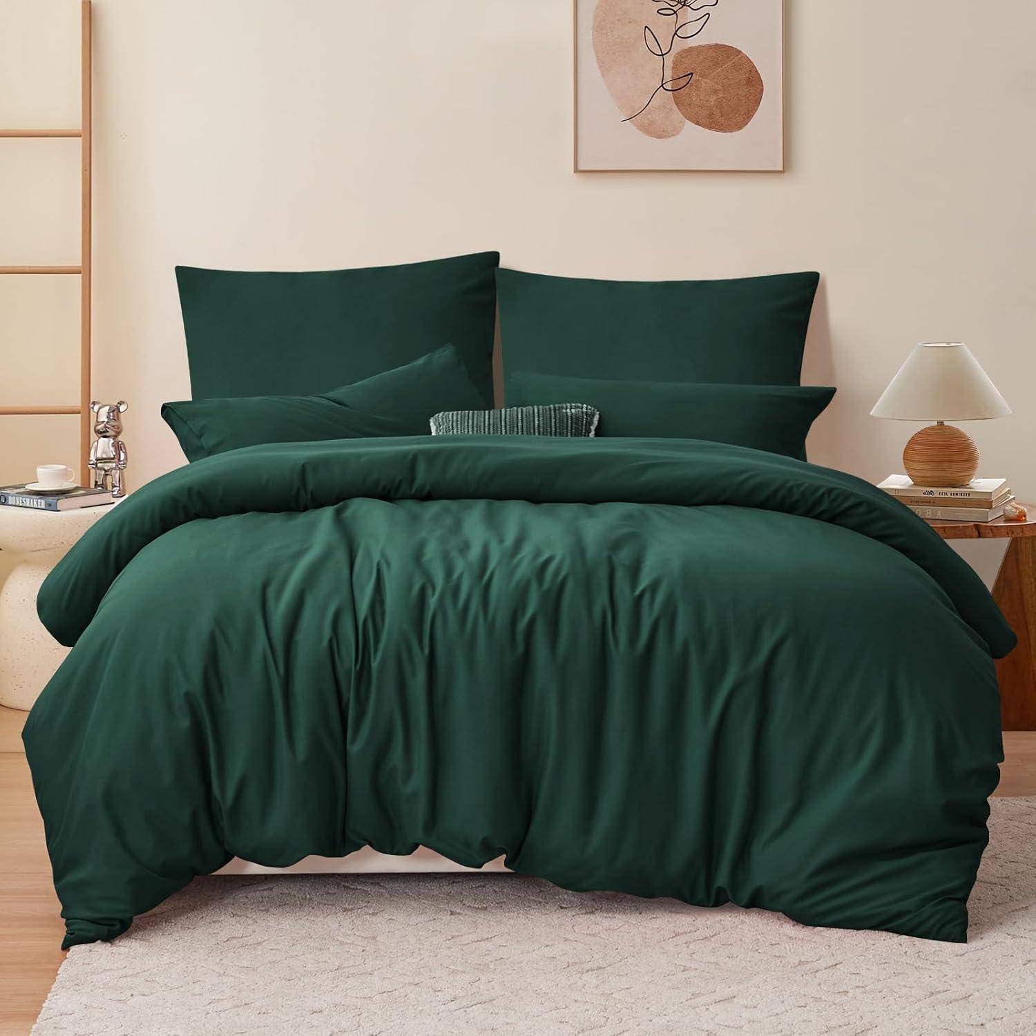 Ein sauber gemachtes Bett mit grüner Bettwäsche, flankiert von Nachttischen mit Lampen. Ein minimalistisches Kunstwerk hängt an der beigen Wand darüber.