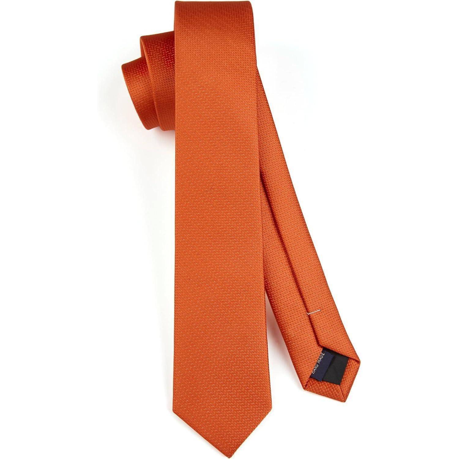 Eine orangefarbene Seidenkrawatte mit strukturierter Oberfläche ist flach ausgebreitet und zeigt ihre spitz zulaufende Spitze und schmale Breite.