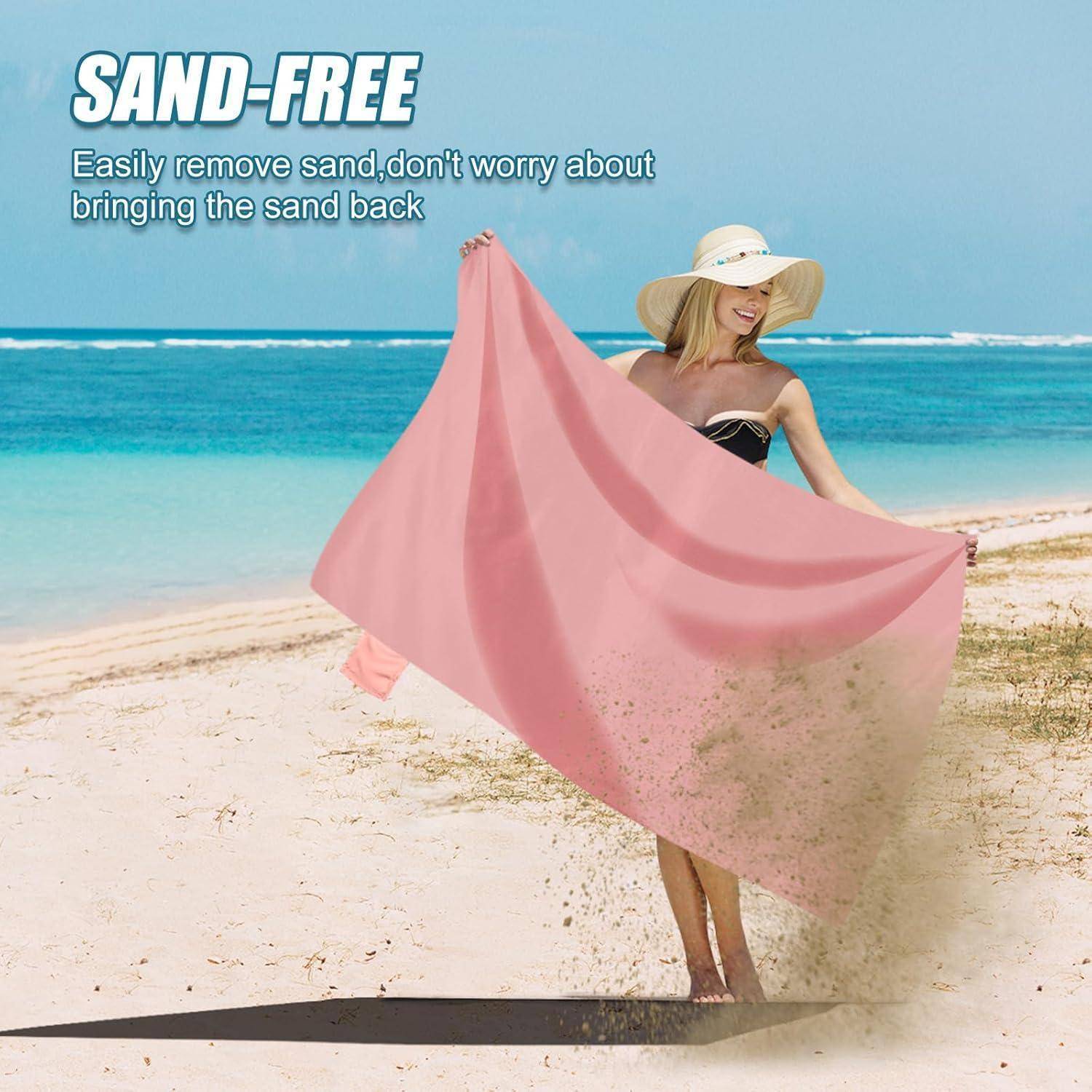 Eine Frau am Strand schüttelt ein pinkes Handtuch mit dem Text: 'SANDFREI. Sand einfach entfernen, keine Sorge mehr, Sand mit nach Hause zu bringen.