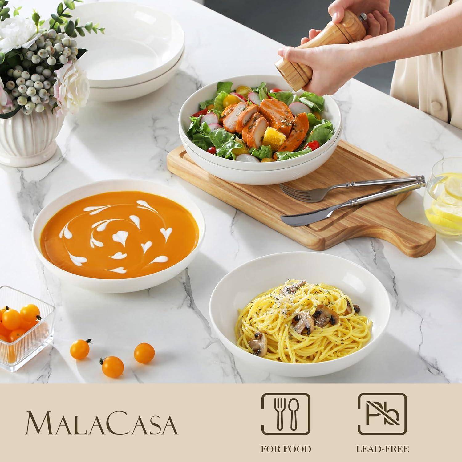 Ein Tisch mit einer Schüssel Salat, einer Schüssel Suppe, einem Teller Pasta und einem Getränk. Eine Person hält eine Schüssel. Text lautet: „MalaCasa FÜR LEBENSMITTEL BLEIFREI