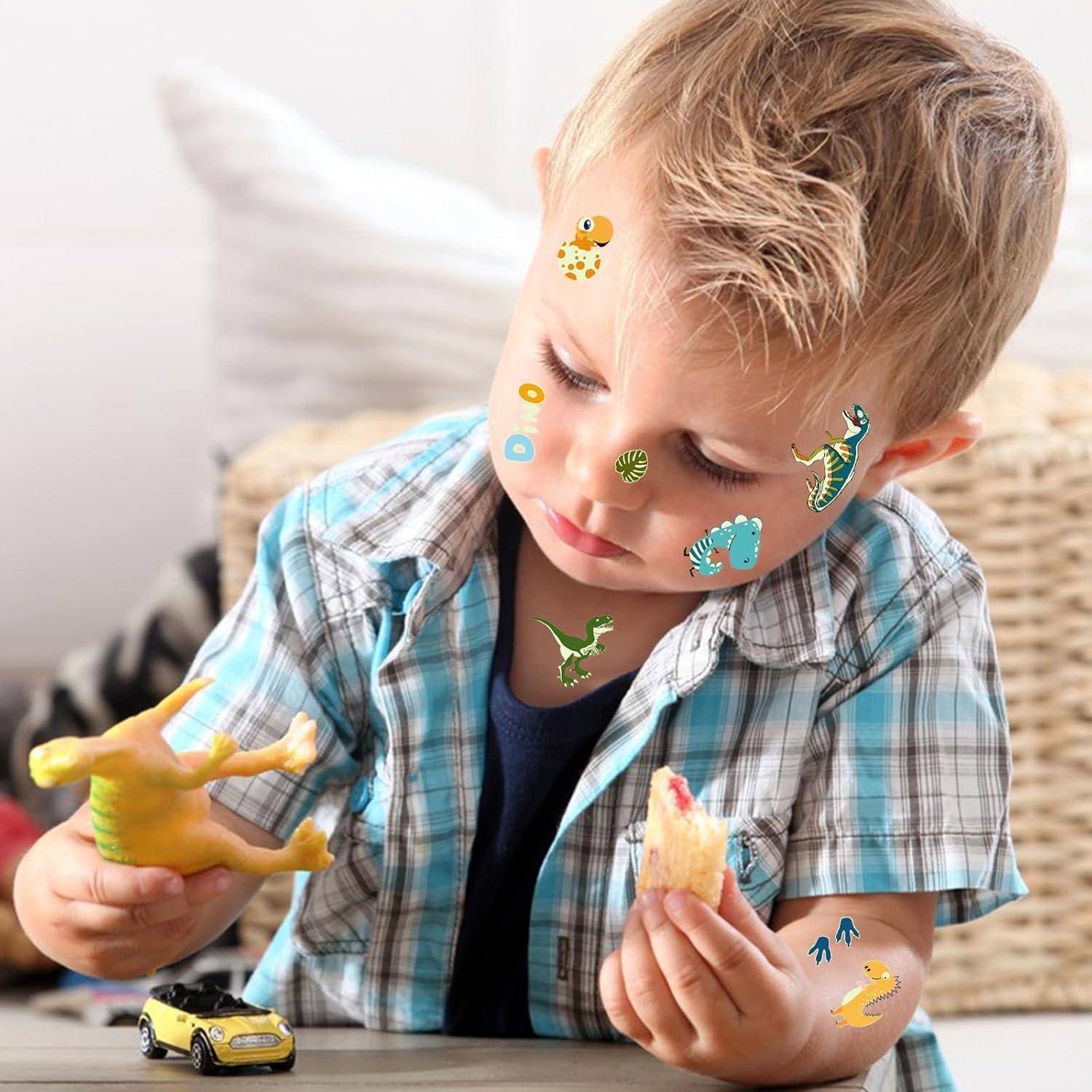 Ein kleines Kind mit Dinosaurier-Stickern im Gesicht und auf der Kleidung spielt mit einem Spielzeugdinosaurier und hält ein Stück Brot in der anderen Hand.