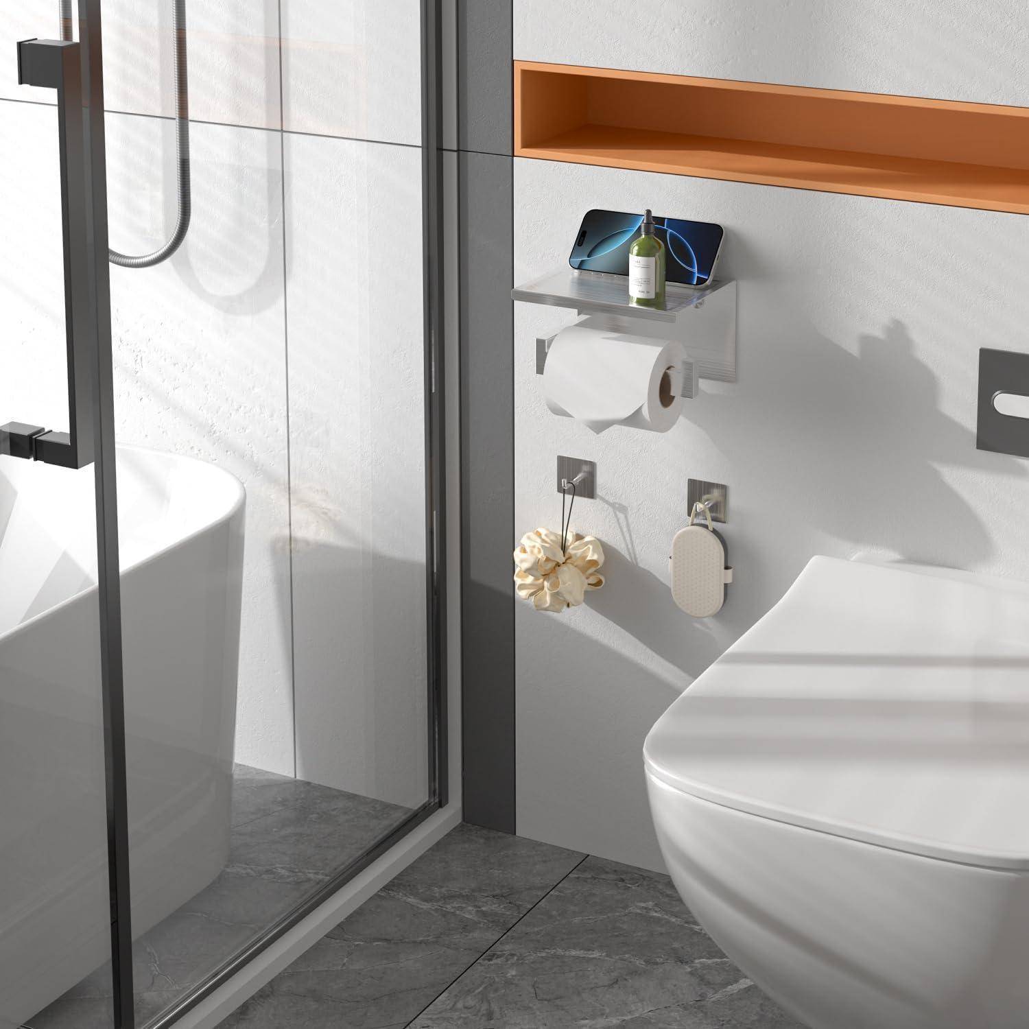 Modernes Badezimmer mit einer Dusche, einer Badewanne und einem wandmontiertem Toilettensitz. Toilettenpapier und Toilettenbürste sind an der Wand befestigt, mit einem Regal darüber.