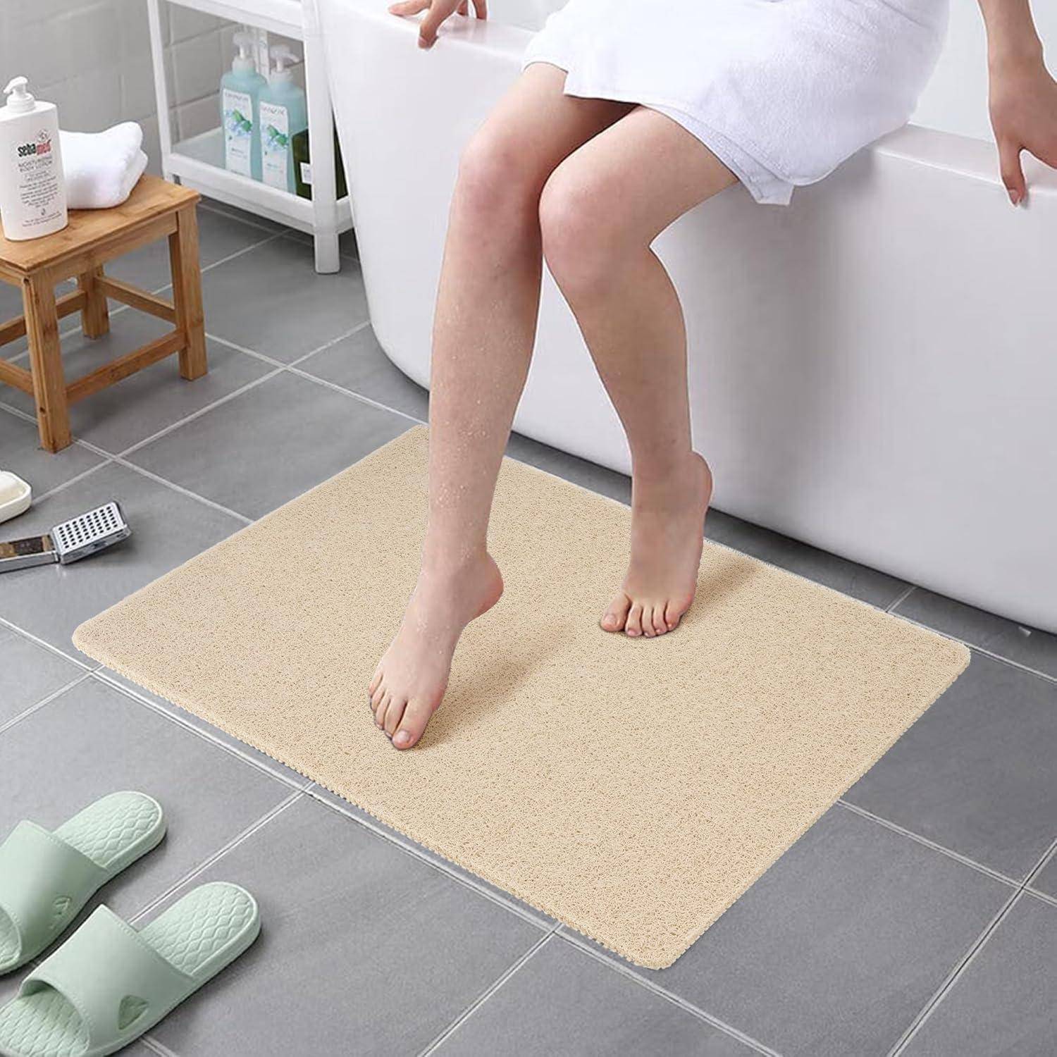 Eine Person sitzt auf dem Rand der Badewanne, die Füße auf einer beigen Badematte. In der Nähe sind Spa-Utensilien ordentlich aufgereiht und deuten auf eine entspannende Atmosphäre hin.