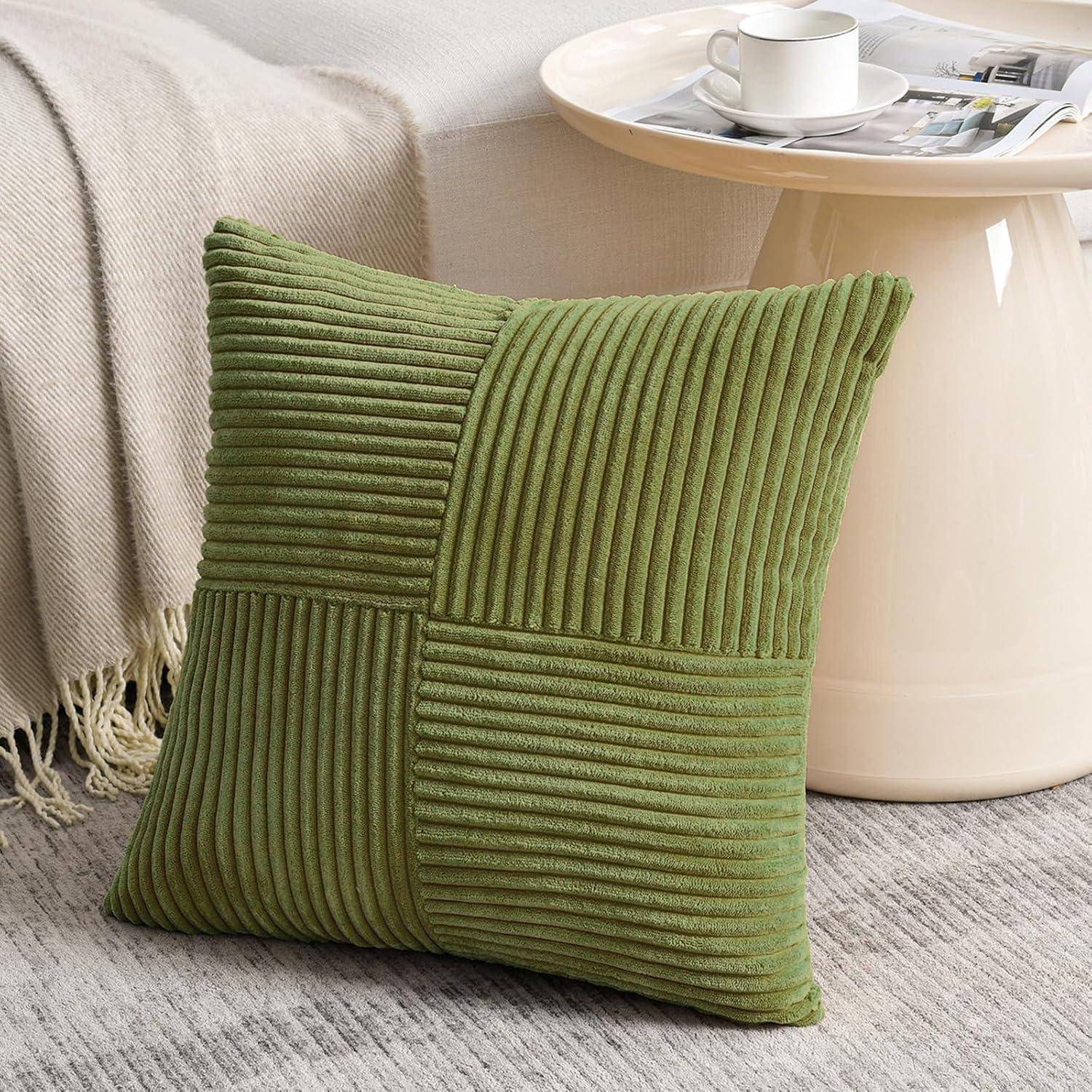 Grünes geripptes Kissen auf einem beigen Teppich, in der Nähe eines cremefarbenen runden Tisches mit einer weißen Kaffeetasse und einem Buch darauf.