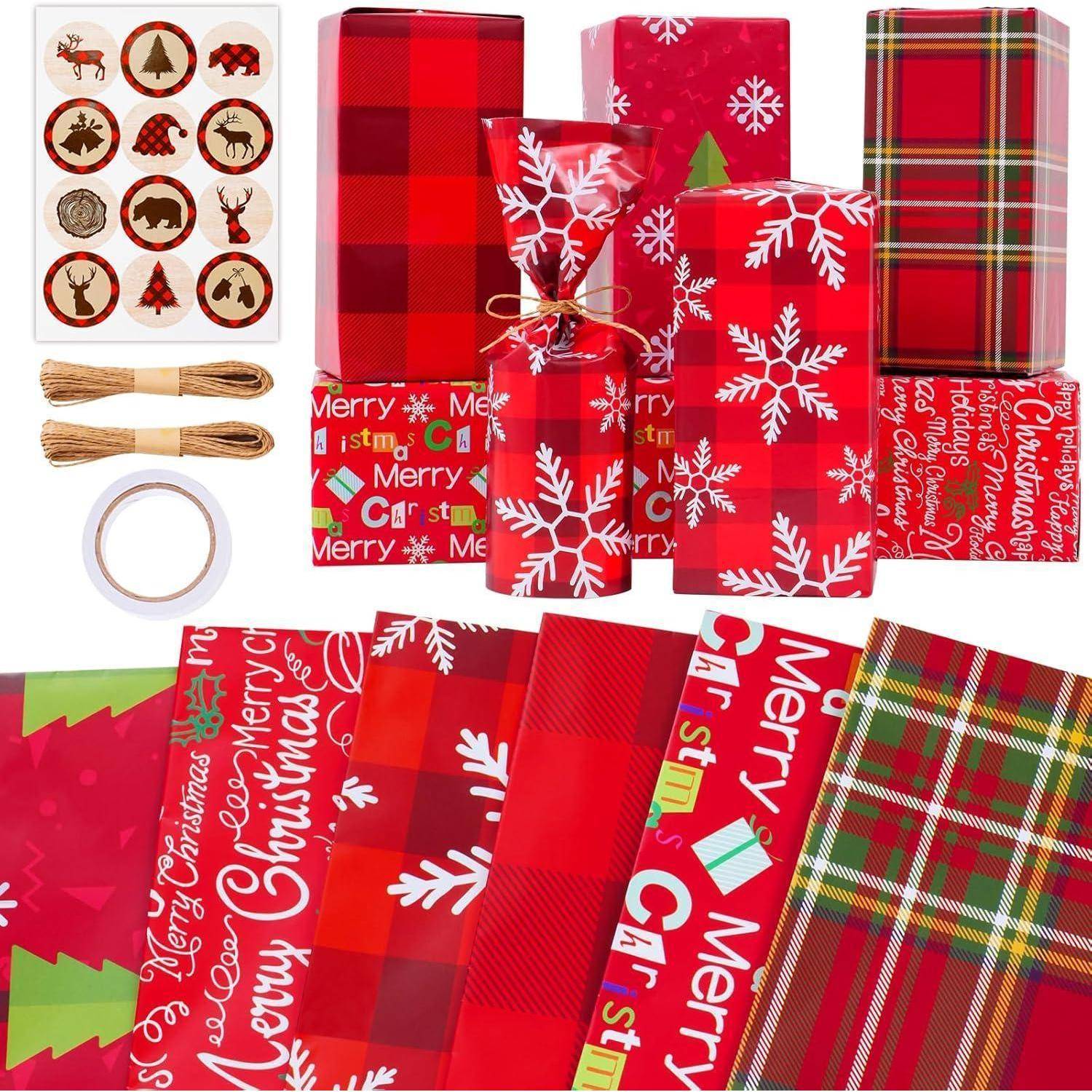 Eine Sammlung von roten und festlichen Geschenkpapieren mit Weihnachtsmotiven, die Designs mit Schneeflocken, Karomuster und 'Frohe Weihnachten' Schriftzug umfasst, zusammen mit Bindfaden und Stickern.