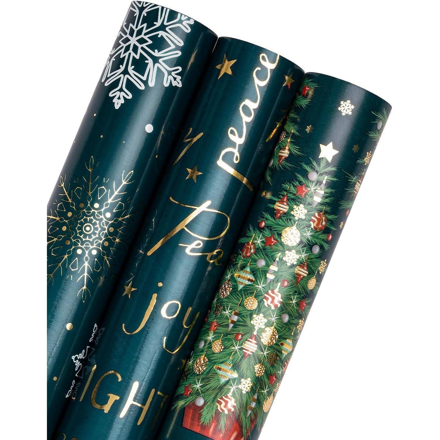 Drei Rollen festliches Geschenkpapier zeigen eine goldene Schrift mit den Worten 