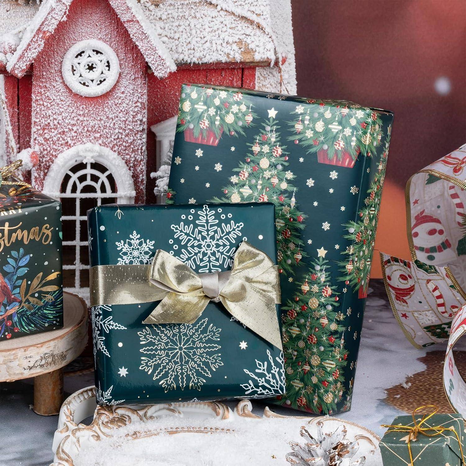 Eine festliche Szene mit in grünes Papier mit Schneeflocken und Weihnachtsbäumen eingepackten Geschenken, einem mit Schnee bedeckten Lebkuchenhaus und weihnachtlicher Dekoration.