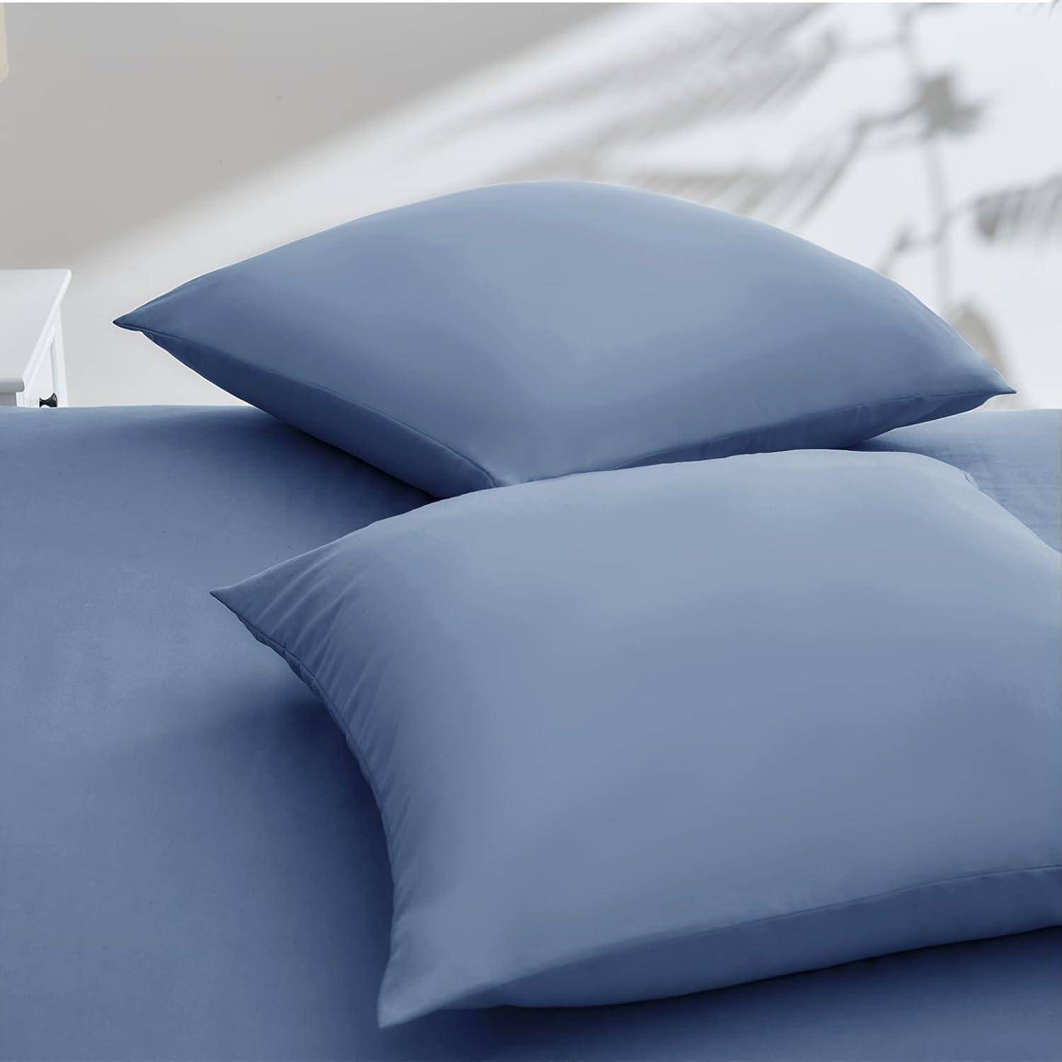 Ein ordentlich gemachtes Bett mit blauen Kissen und Bettwäsche, das sich in einem minimalistischen Raum mit unscharfem Hintergrund befindet und eine ruhige Atmosphäre erzeugt.