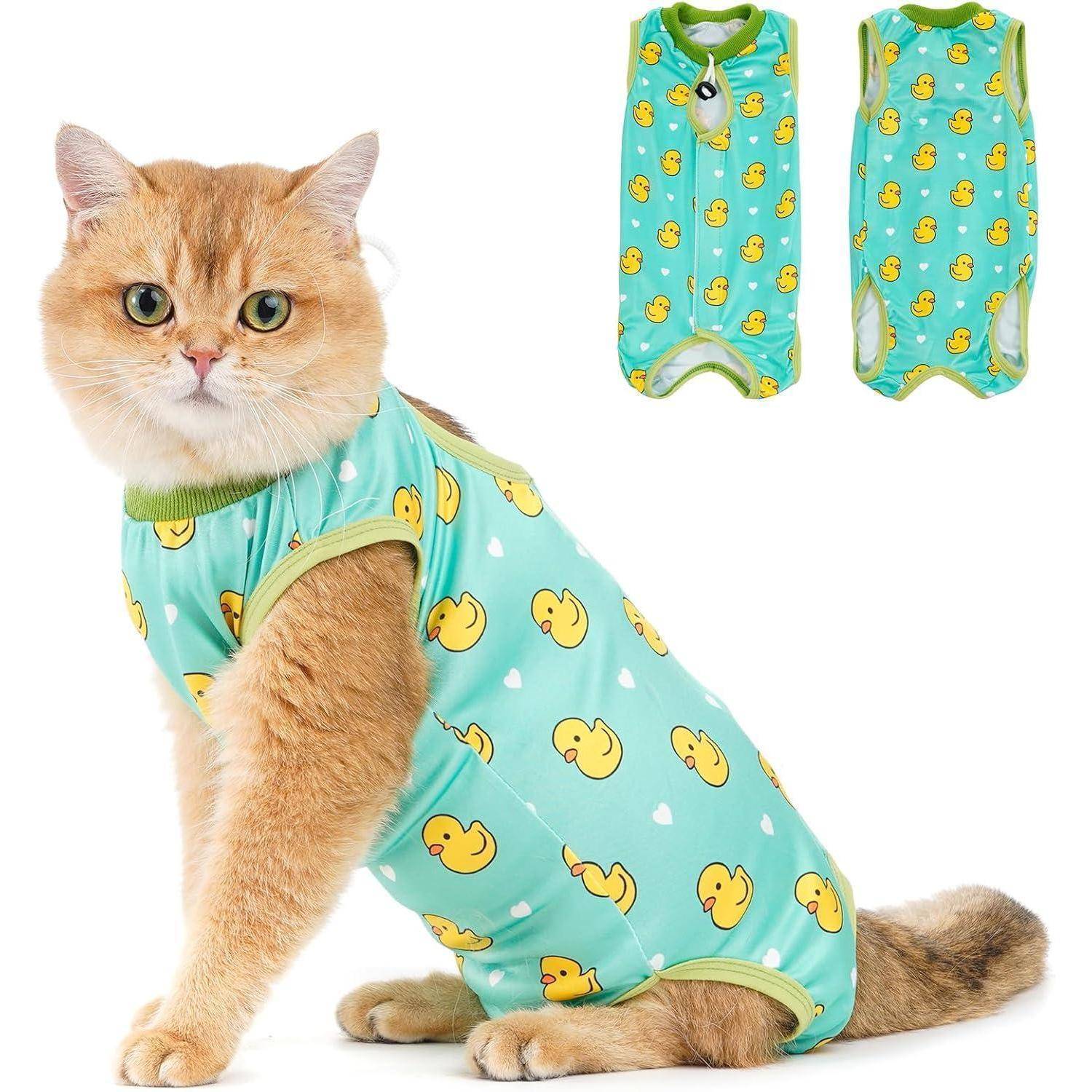 Eine Katze trägt eine blaue Kleidung mit gelben Entenabdrücken und sitzt nach vorne gerichtet. Zwei weitere Kleidungsstücke mit demselben Design werden oben gezeigt.