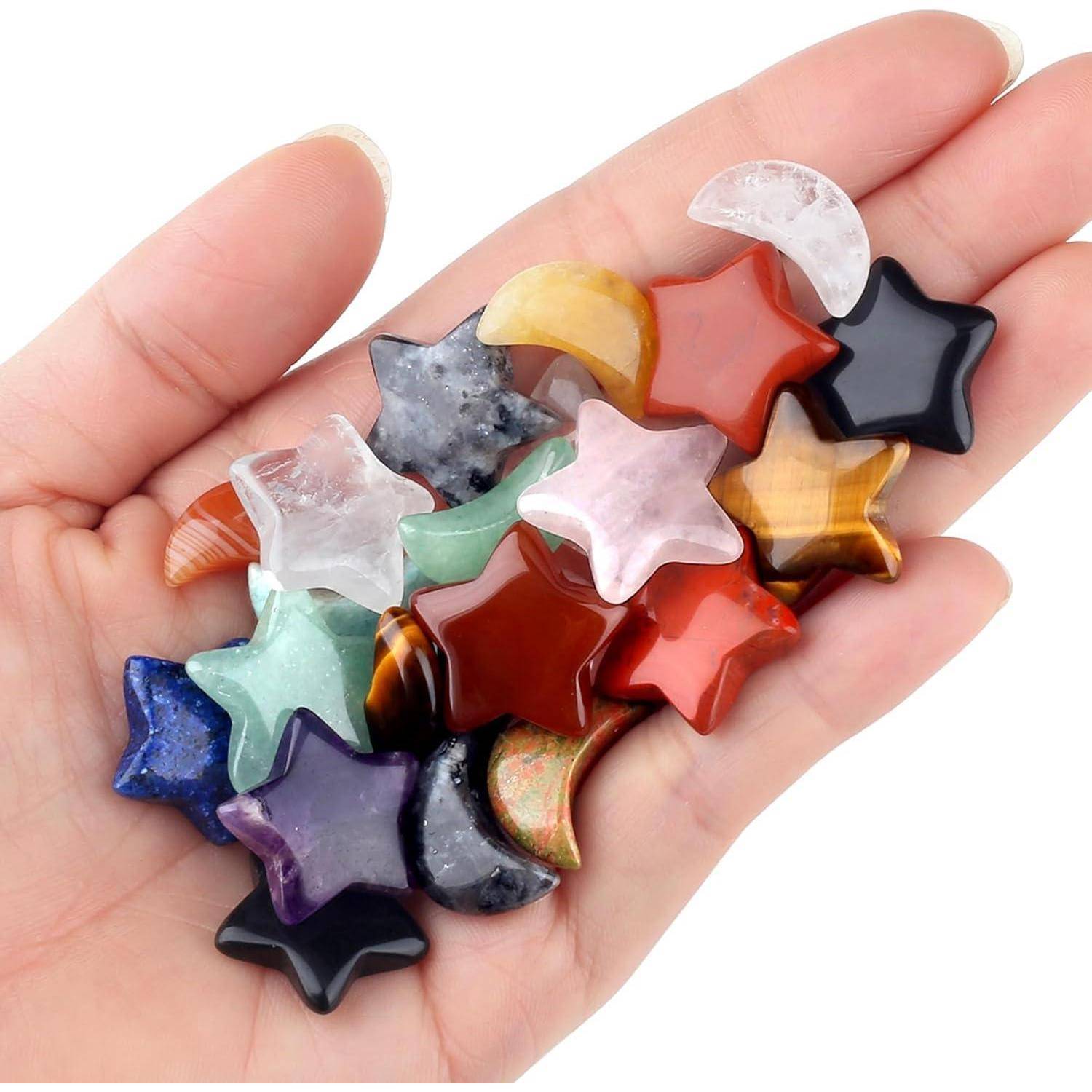 Eine Hand hält bunte Edelstein-Sterne und Halbmonde, die eine Vielzahl von Mustern und Farbtönen zeigen und verschiedene Mineralarten repräsentieren.