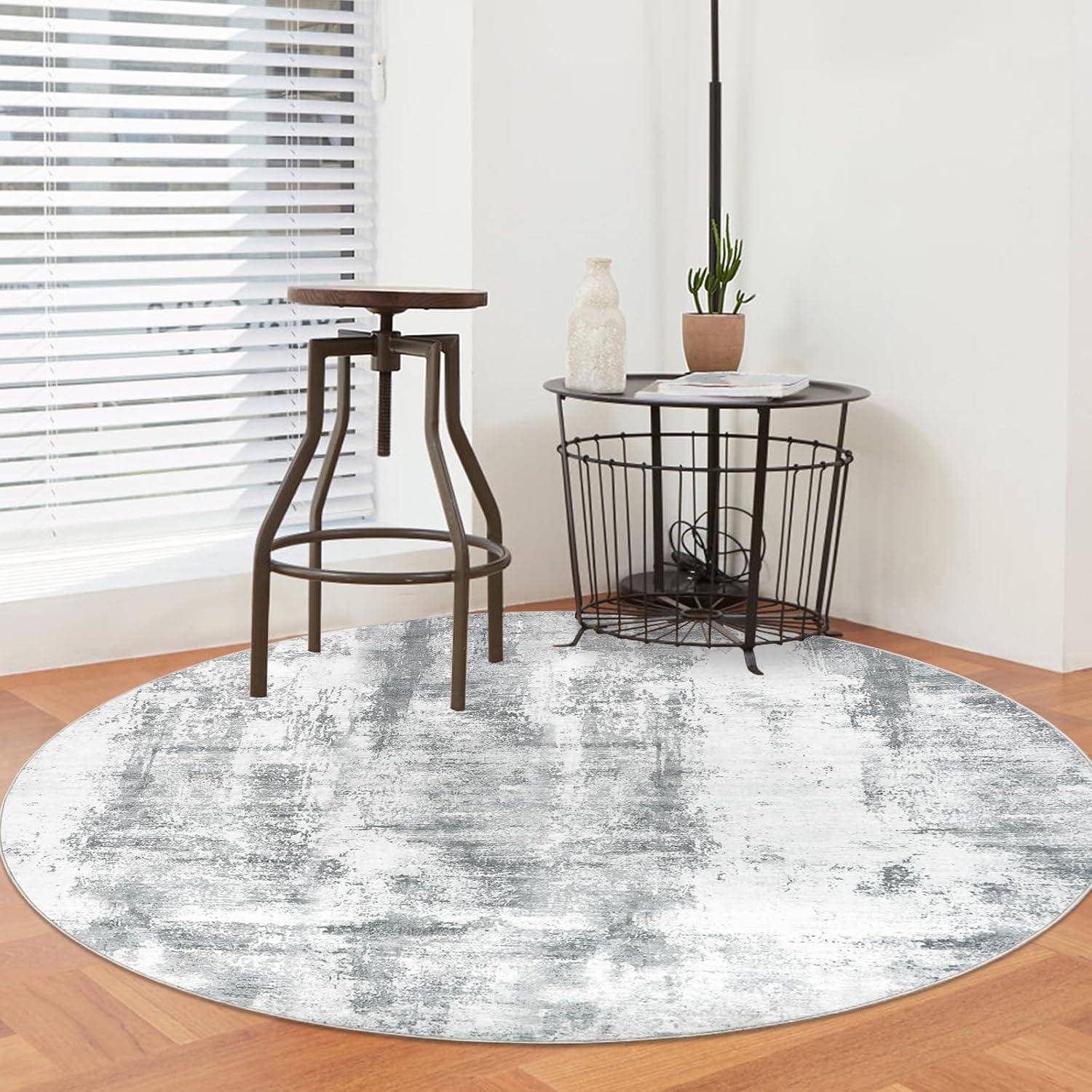 Ein modernes Zimmer mit einem Metallstuhl und einem hohen Beistelltisch auf einem grau-weißen Rundeteppich. Eine Pflanze und eine Vase stehen auf einem Drahtständer.