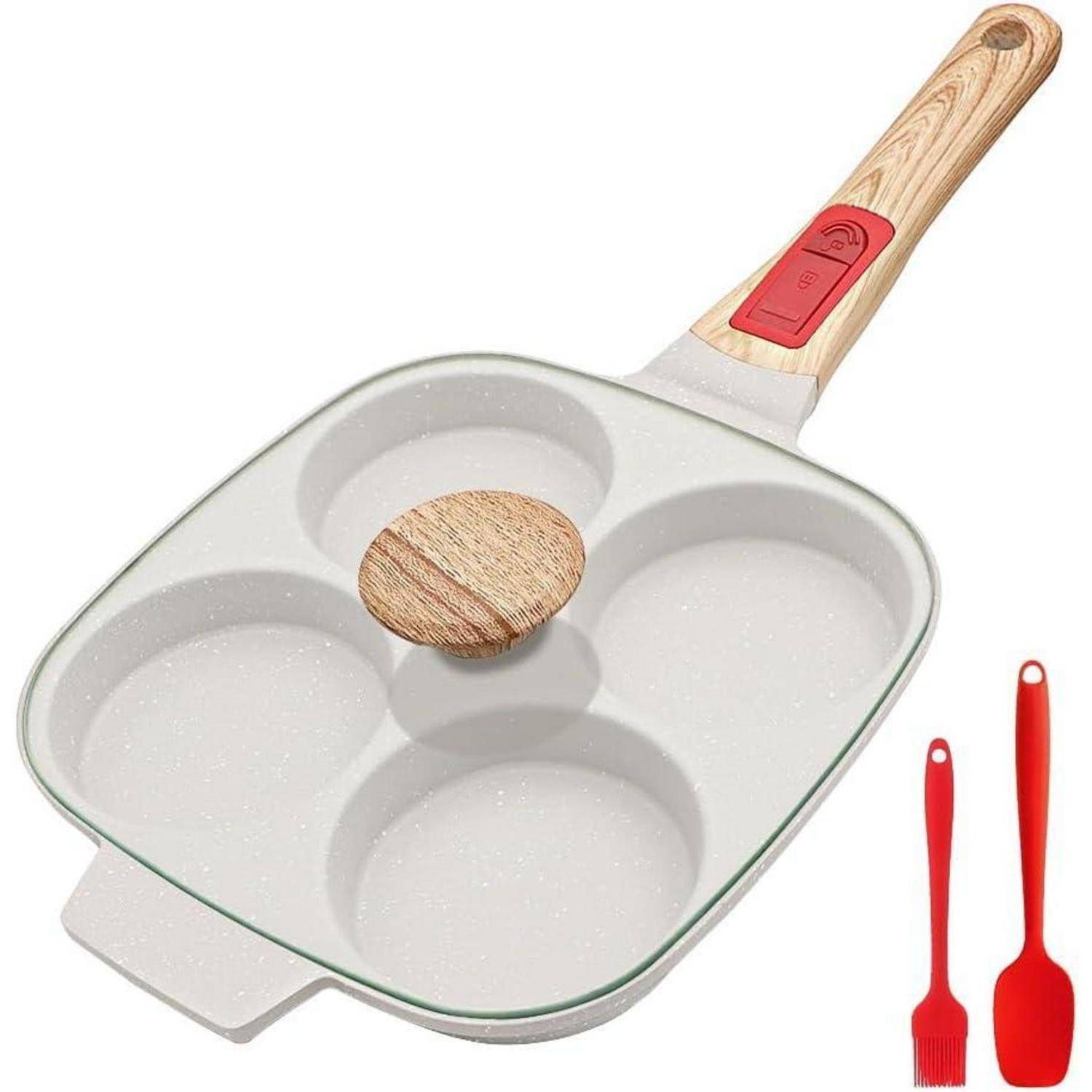 Vier-Loch-Pfanne zum Eierbraten mit einem Holzgriff auf weißem Hintergrund, zusammen mit einem roten Pfannenwender und Pinsel.