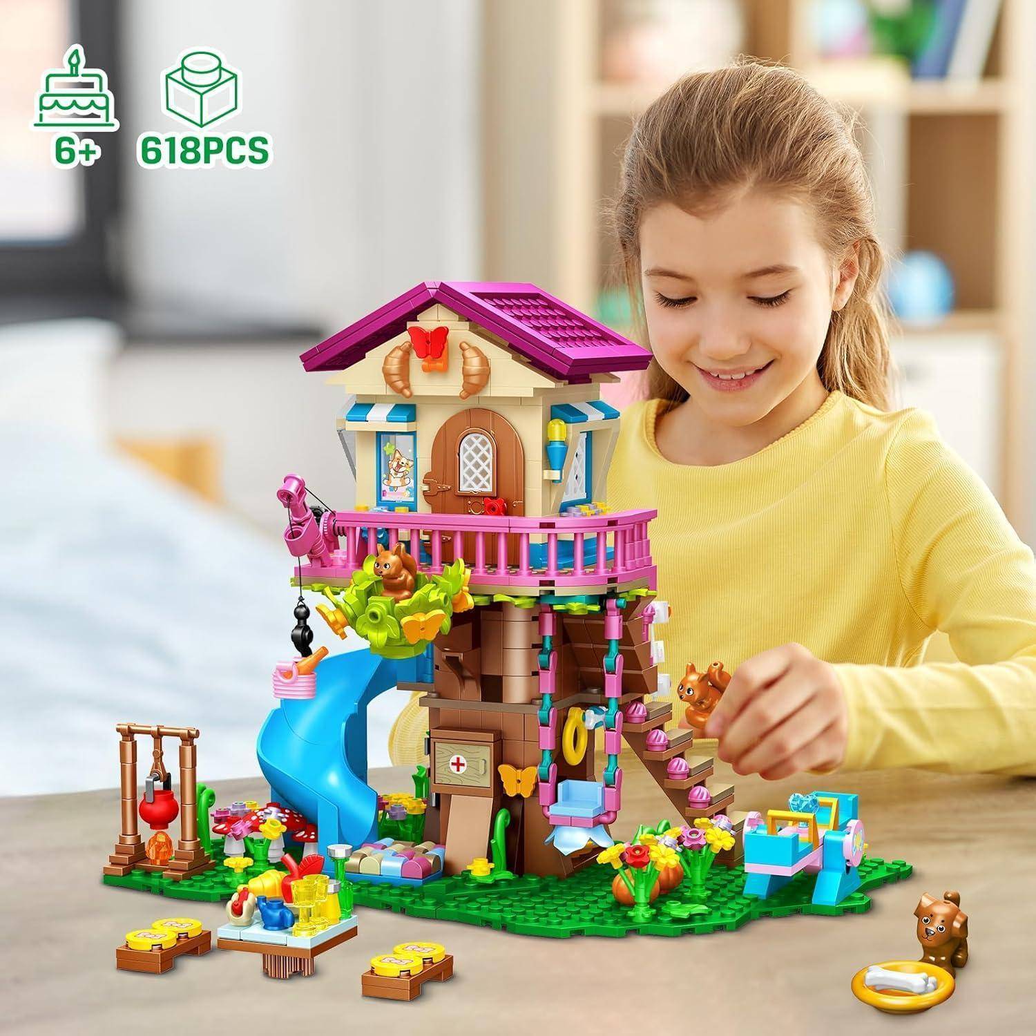 Ein Kind, das mit einem bunten Baumhaus-Spielzeugset spielt, das eine blaue Rutsche und verschiedene Zubehörteile enthält, gekennzeichnet für Kinder ab 6 Jahren mit 618 Teilen.