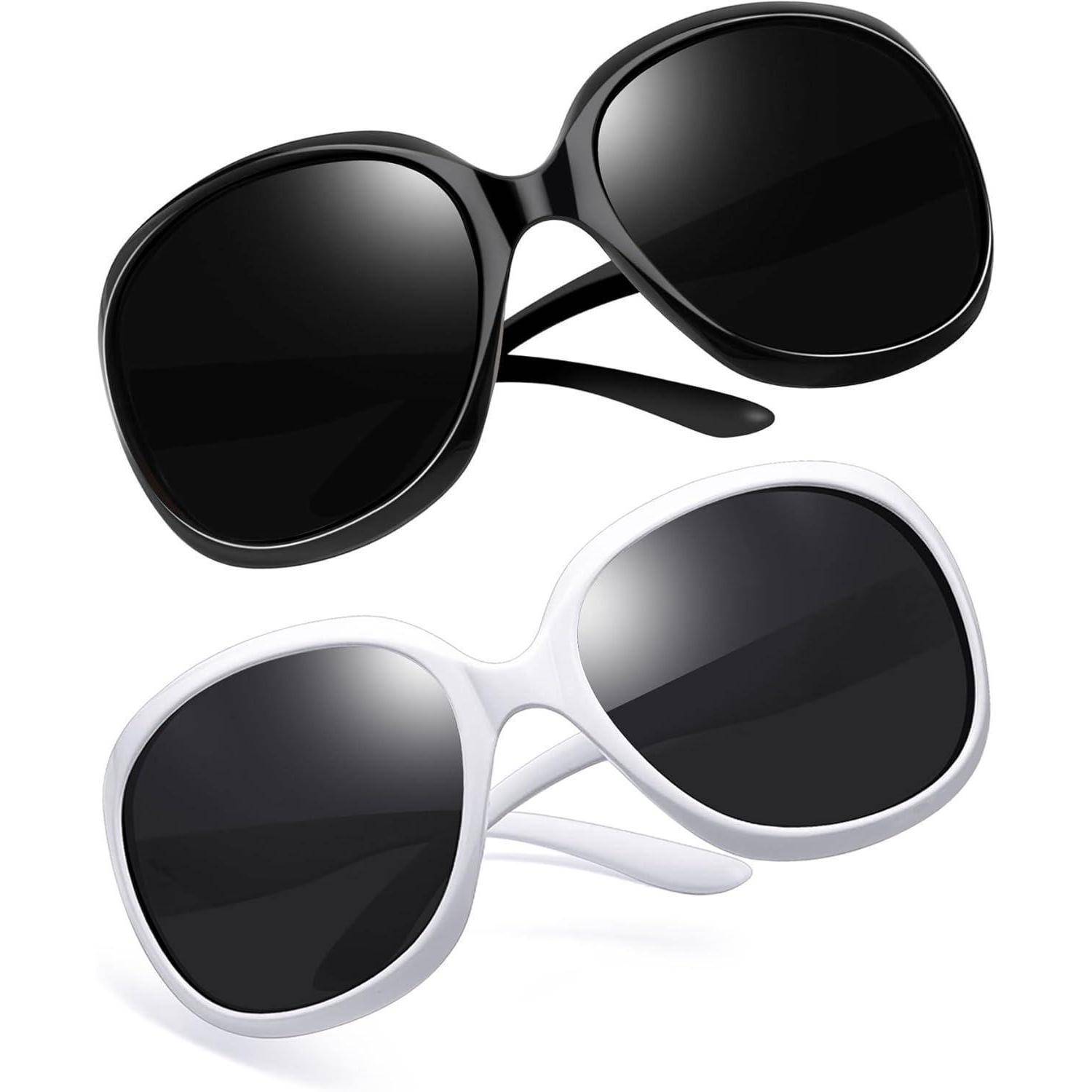 Zwei Paare überdimensionaler Sonnenbrille: eines in Schwarz und eines in Weiß, beide mit dunklen Gläsern, so positioniert, als würden sie mitten im Fallen gegen einen einfarbigen Hintergrund schweben.