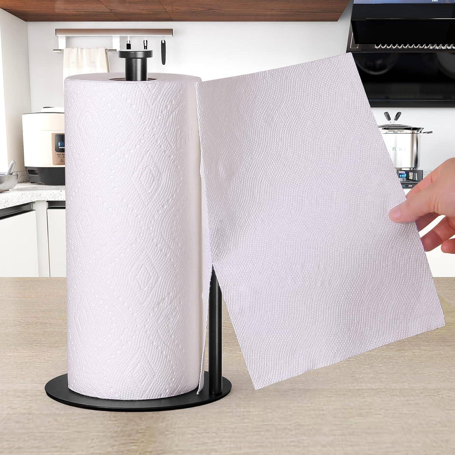 Eine Hand zieht ein Blatt von einer Rolle weißer Küchenrolle, die vor einem Küchenhintergrund auf einem Halter befestigt ist.