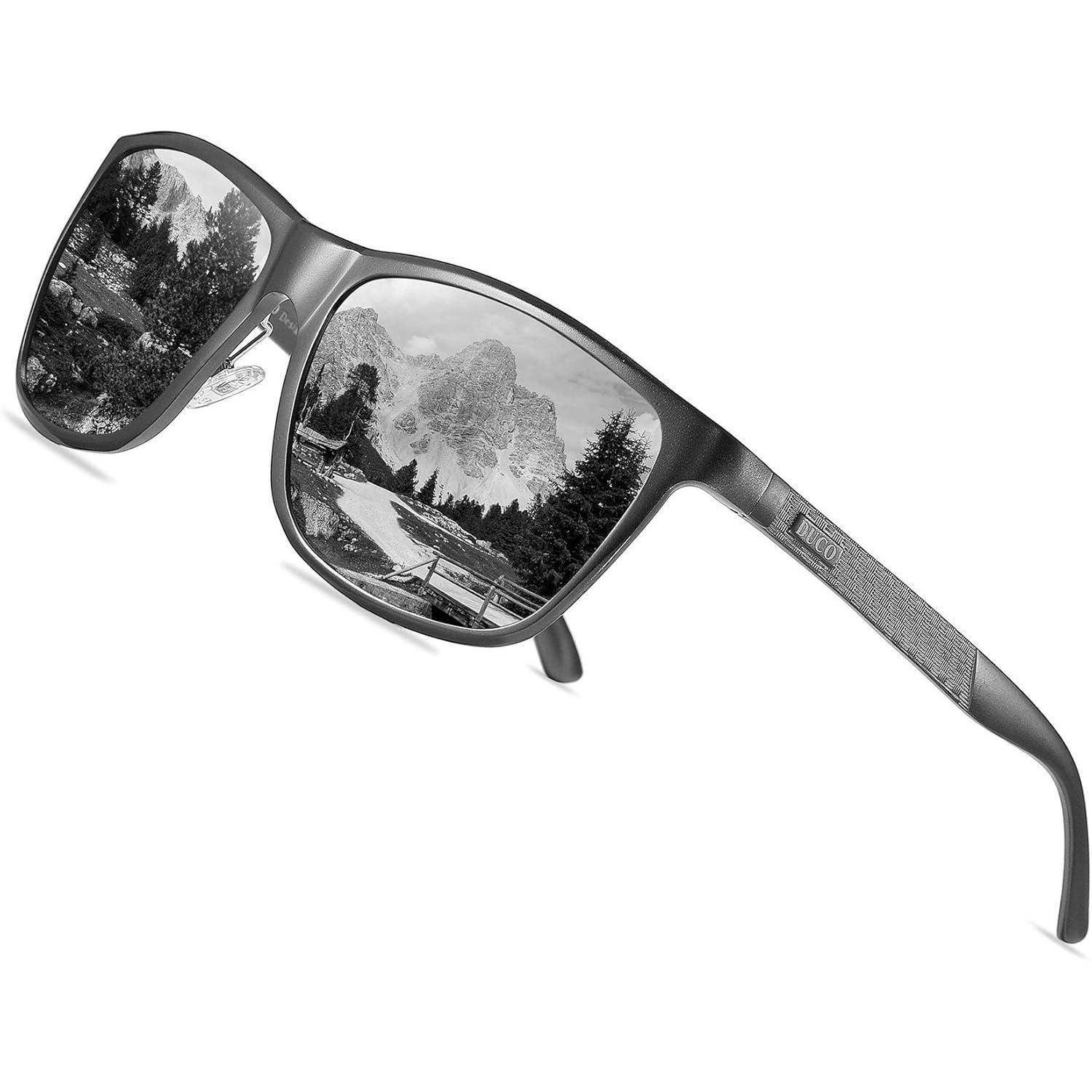 Schwarze Sonnenbrille mit einer Linse, die eine Bergszene zeigt, und der anderen, die einen Waldweg präsentiert und damit unterschiedliche Landschaftsspiegelungen hervorhebt.