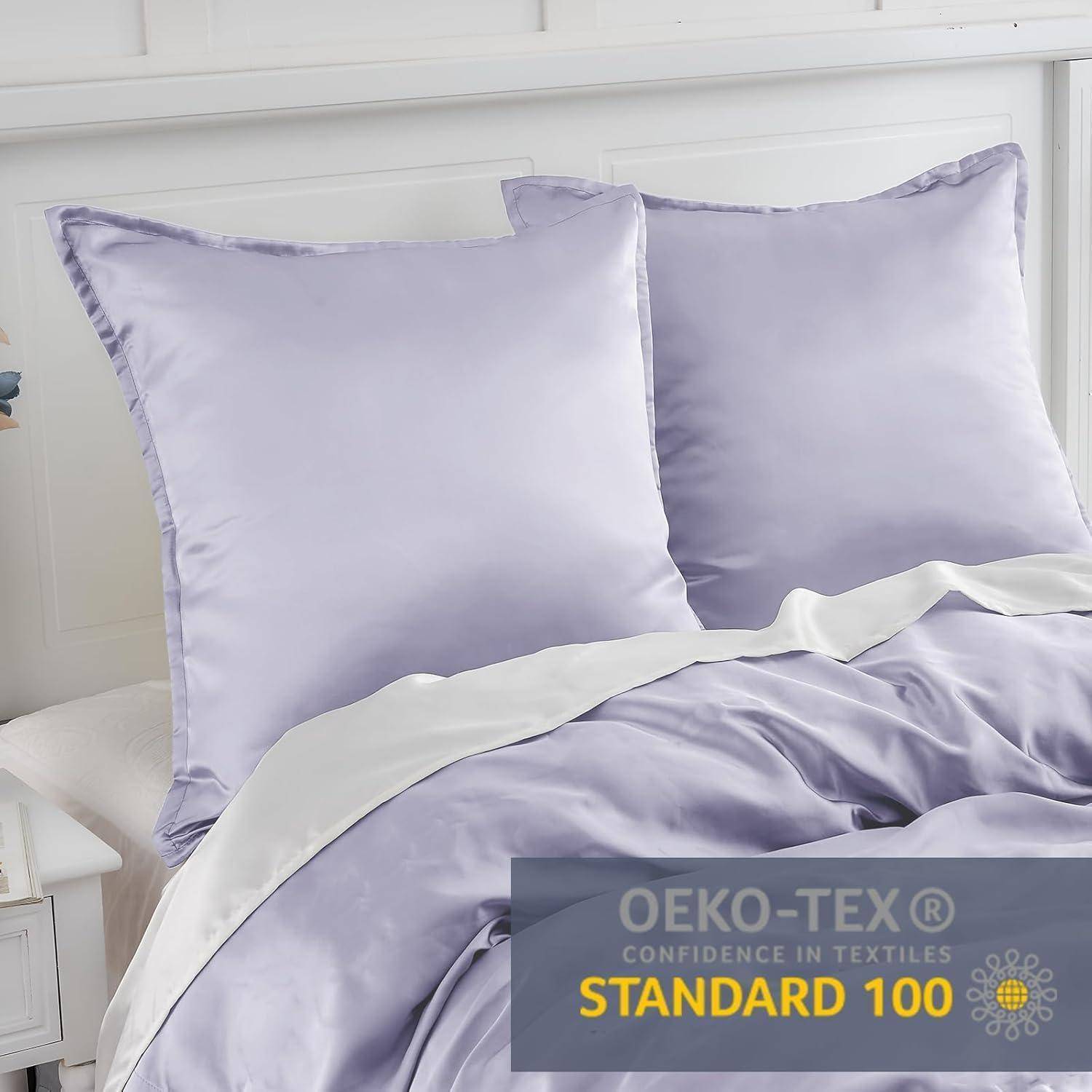 Zwei Lavendelkissen auf einem Bett mit passender Satin-Bettwäsche, an deren Ecke ein Zertifizierungsetikett des 'OEKO-TEX Standard 100' angebracht ist.