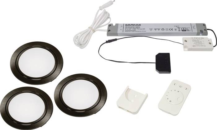 LED-Unterbauleuchten-Set mit drei runden Leuchten, einem Netzteil, einer Fernbedienung und Befestigungsmaterial, geeignet für den Einsatz unter Schränken.