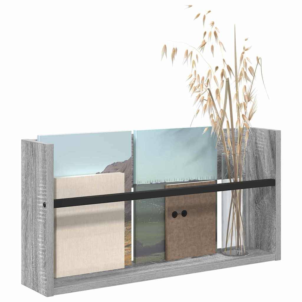 Ein Holzregal mit verschiedenen Landschaftsbildern und Pflanzen, die auf der rechten Seite teilweise von getrockneten Zweigen verdeckt werden.