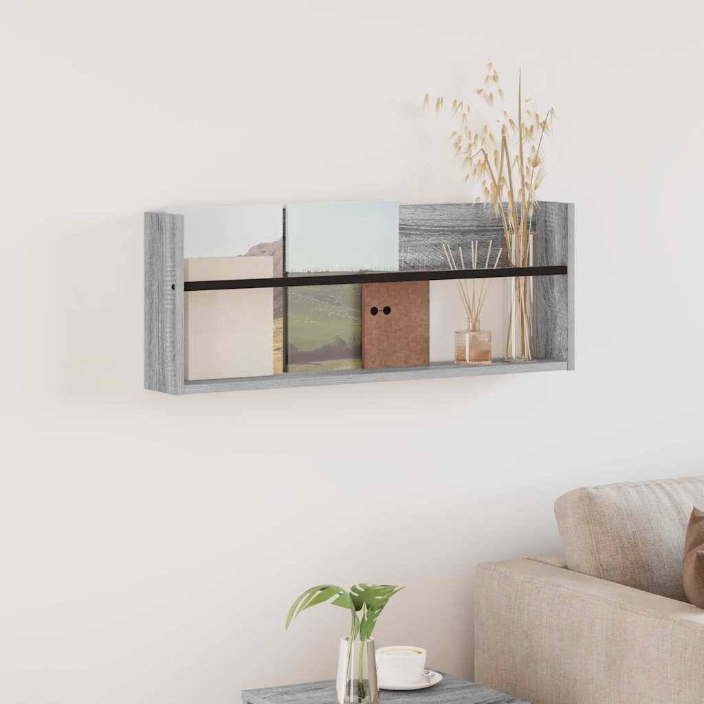 Ein modernes Wohnzimmerregal mit dekorativen Gegenständen, darunter Bücher, Vasen und Pflanzen, vor einer weißen Wand. Ein gemütliches Sofa ist teilweise zu sehen.