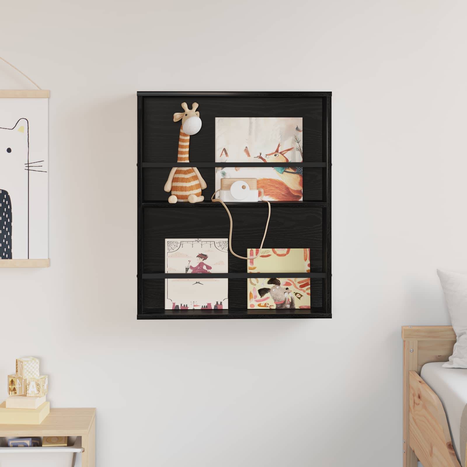 Schwarzes Regal an der Wand hält Kinderkunst, eine Spielzeug-Giraffe und eine kleine Lampe. Bettrand und Katzenillustration teilweise sichtbar.