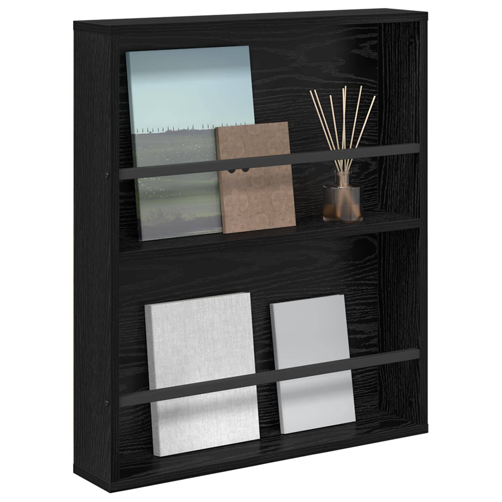 Schwarzes wandmontiertes Regal mit drei Ebenen, das gerahmte Fotos, dekorative Stäbe in einem Glascontainer und Blanko-Bücher zur Dekoration trägt.