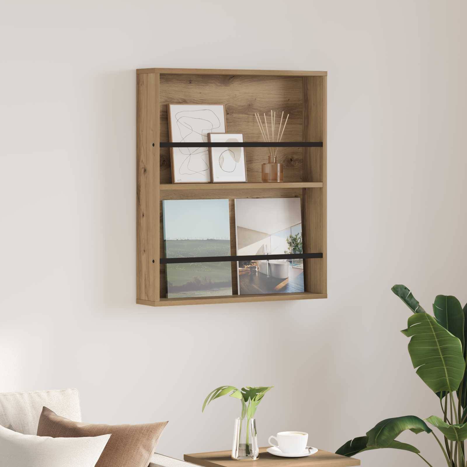 Ein Holzregal mit zwei gerahmten Kunstwerken, einem Foto einer Küstenlandschaft und einem Diffuser. Eine grüne Pflanze und ein kleiner Tisch befinden sich in der Nähe.