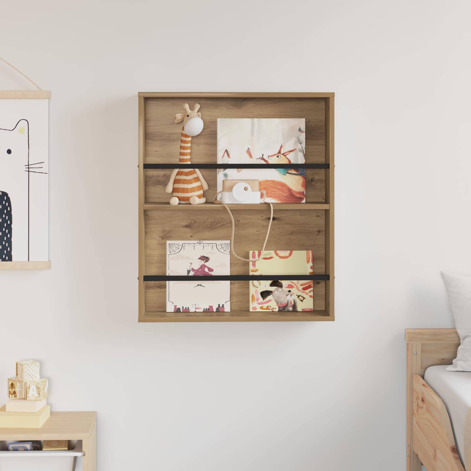 Ein Holzregal trägt eine ausgestopfte Giraffe, kleine gerahmte Kunstwerke und Bücher. Eine weiße Wand im Hintergrund zeigt teilweise Kunstwerke.
