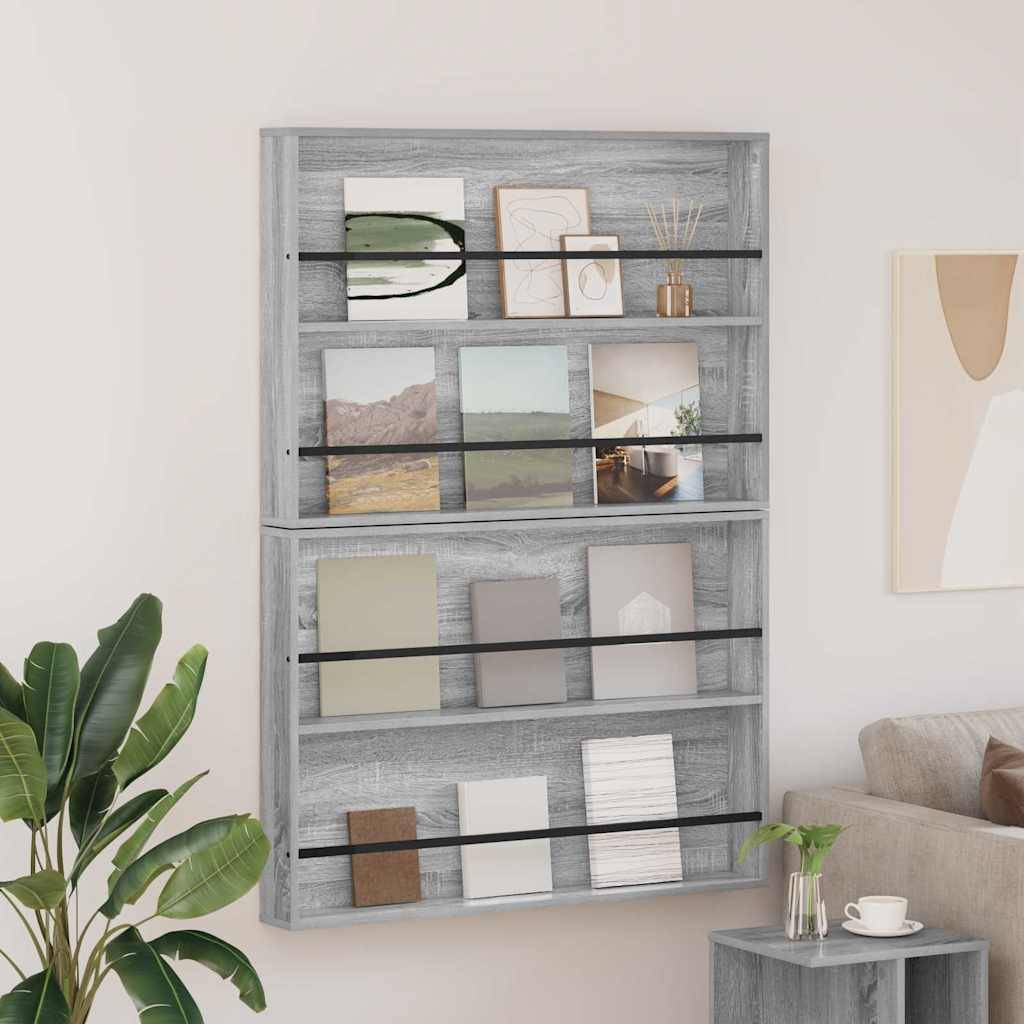 Ein Bücherregal aus Holz, an der Wand befestigt, trägt verschiedene Bücher und Dekorationsgegenstände. Neben einem grauen Sofa ist eine Pflanze zu sehen.