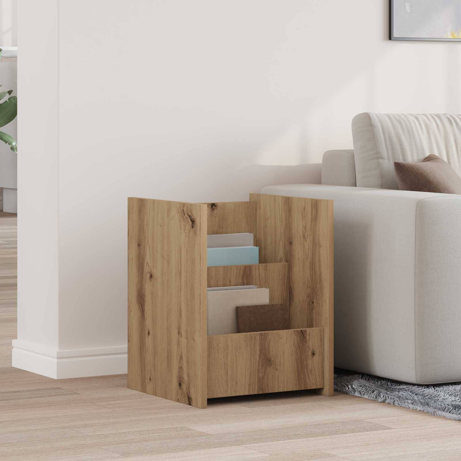 Ein kleines Bücherregal aus Holz trägt ein paar Bücher und steht neben einem weißen Sofa in einem Wohnzimmer mit hellem Holzboden.