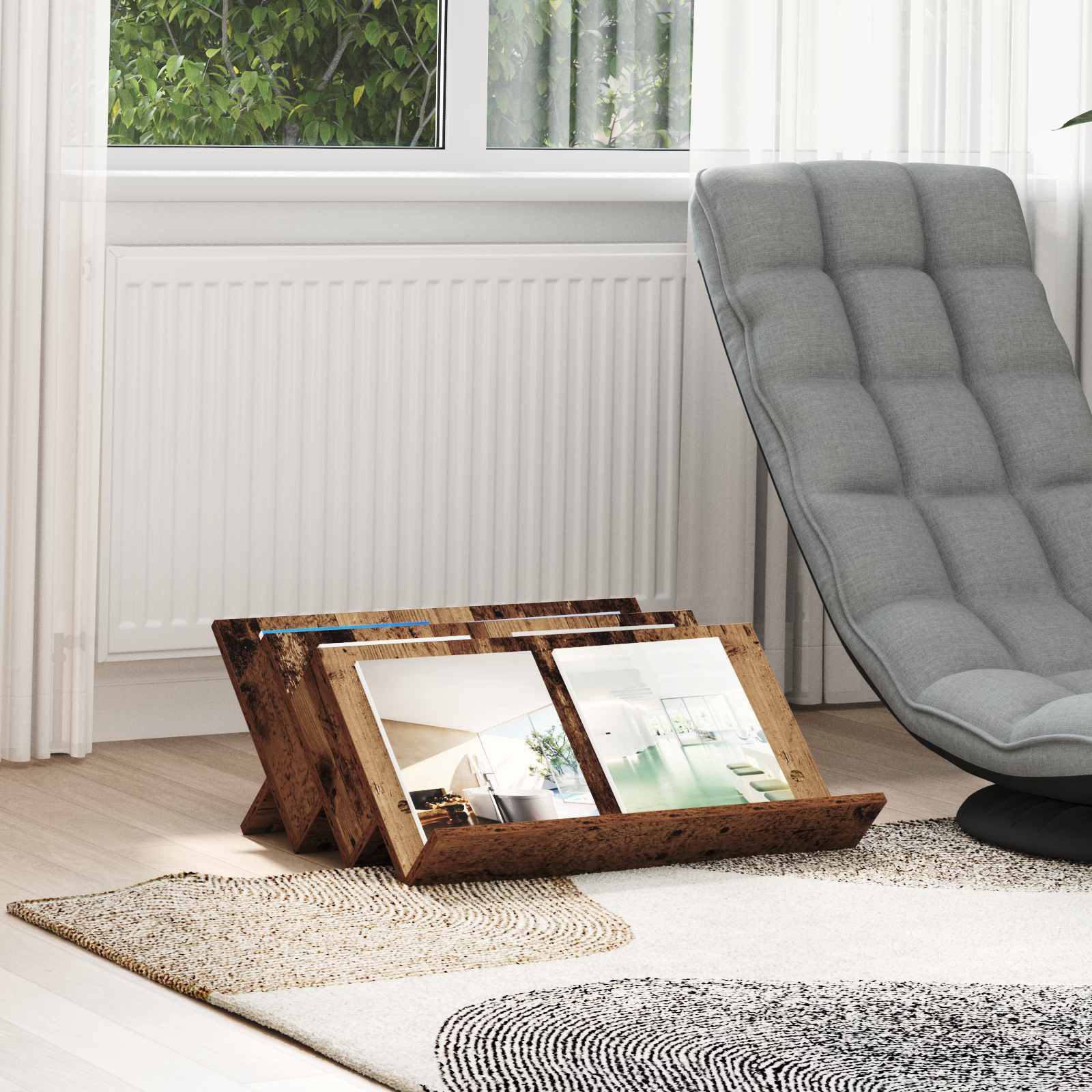 Eine moderne, minimalistische Ecke eines Wohnzimmers mit einem grauen gepolsterten Stuhl, zwei gerahmten Fotos auf einem strukturierten Teppich und einem großen Fenster mit Grünpflanzen draußen.